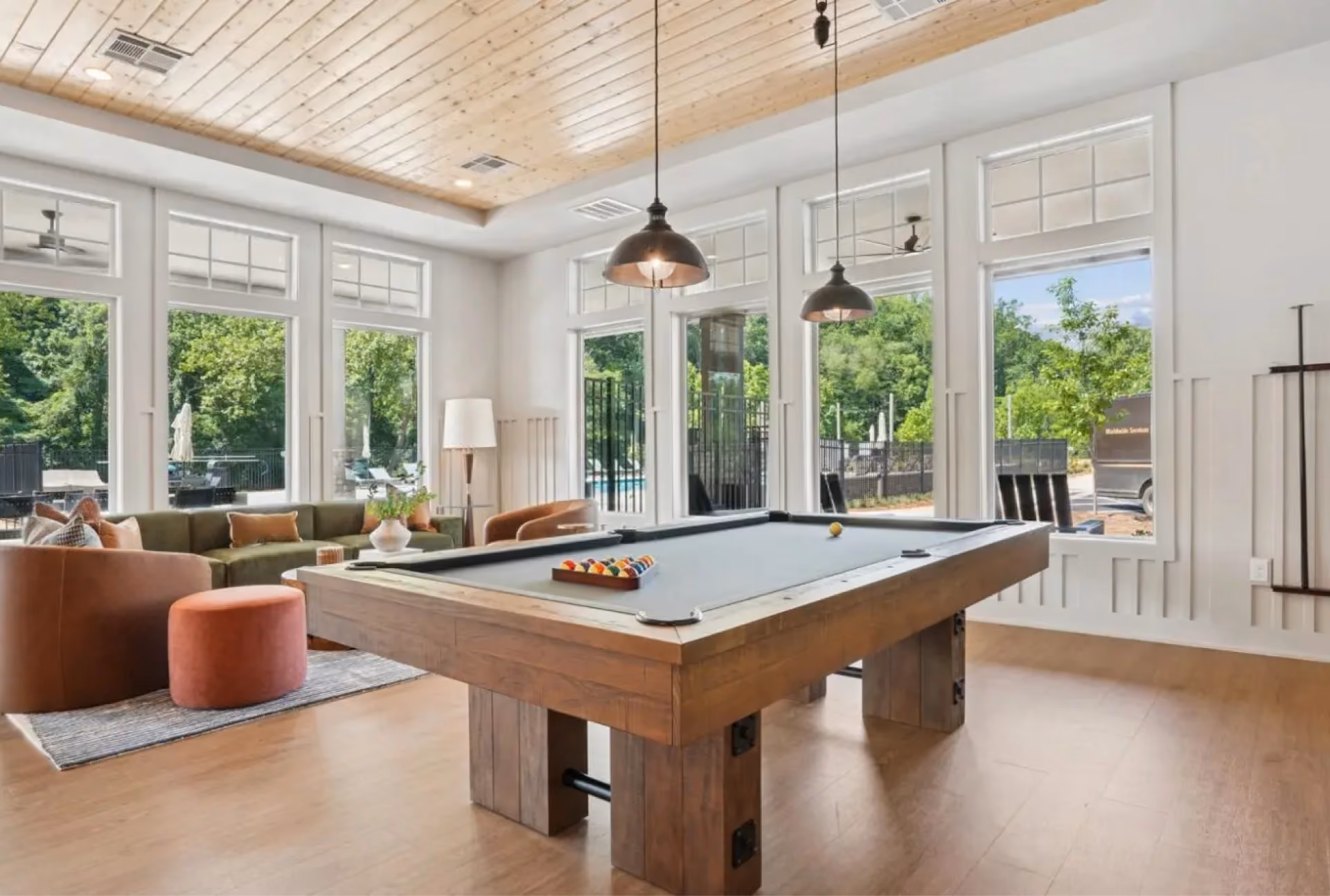Bright sunroom with a pool table and wood-look vinyl plank flooring