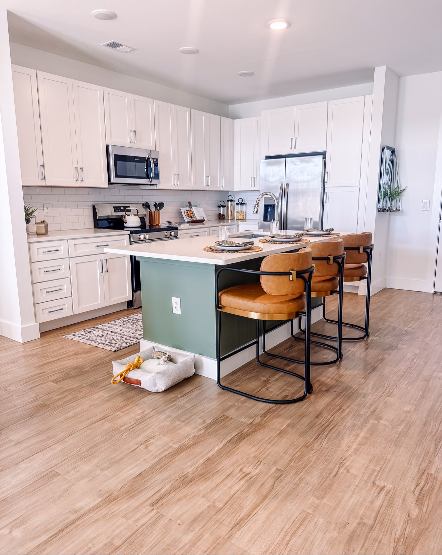 Kitchen with a green island and wood-look vinyl plank flooring