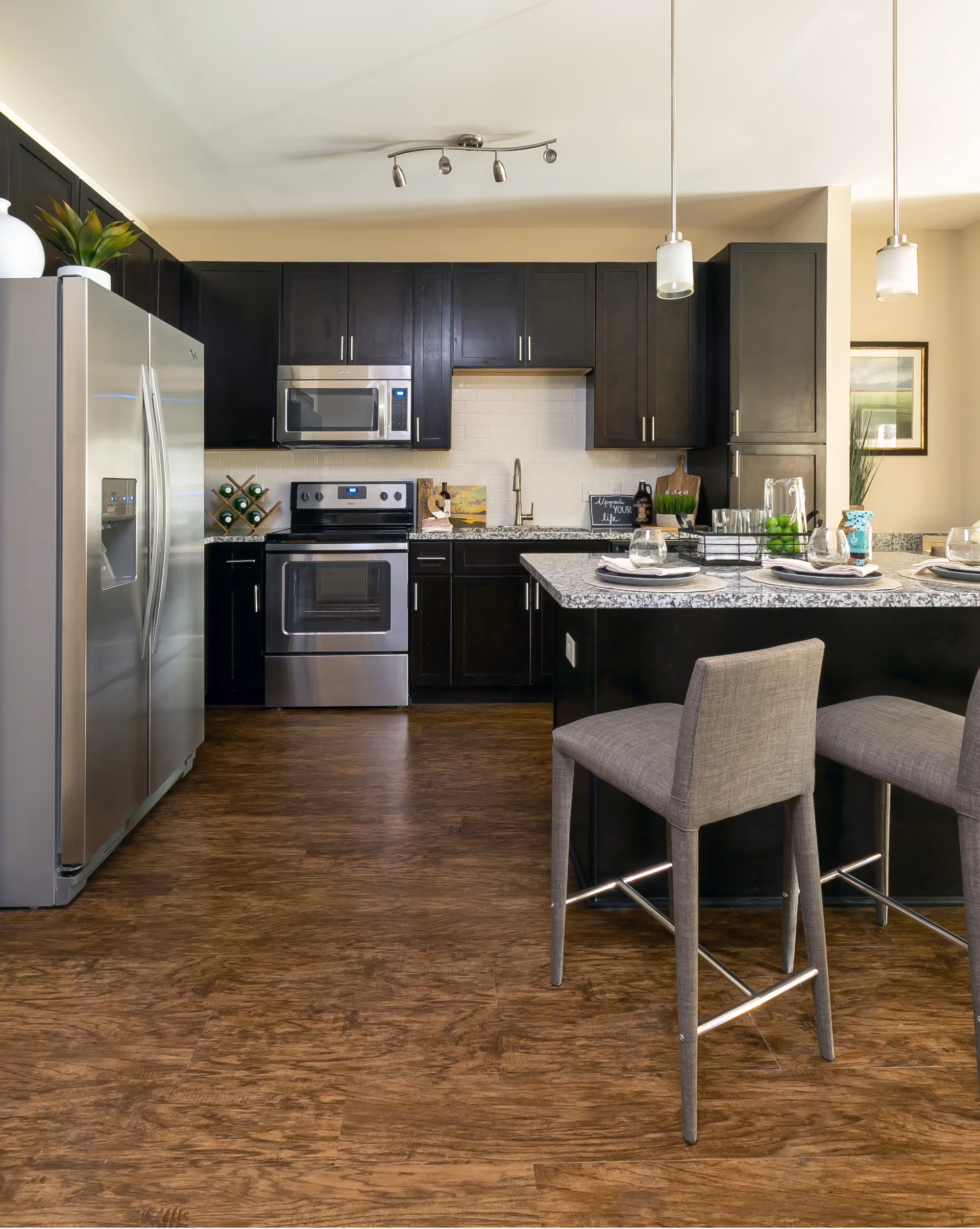 Kitchen with dark cabinetry and wood-look vinyl plank flooring