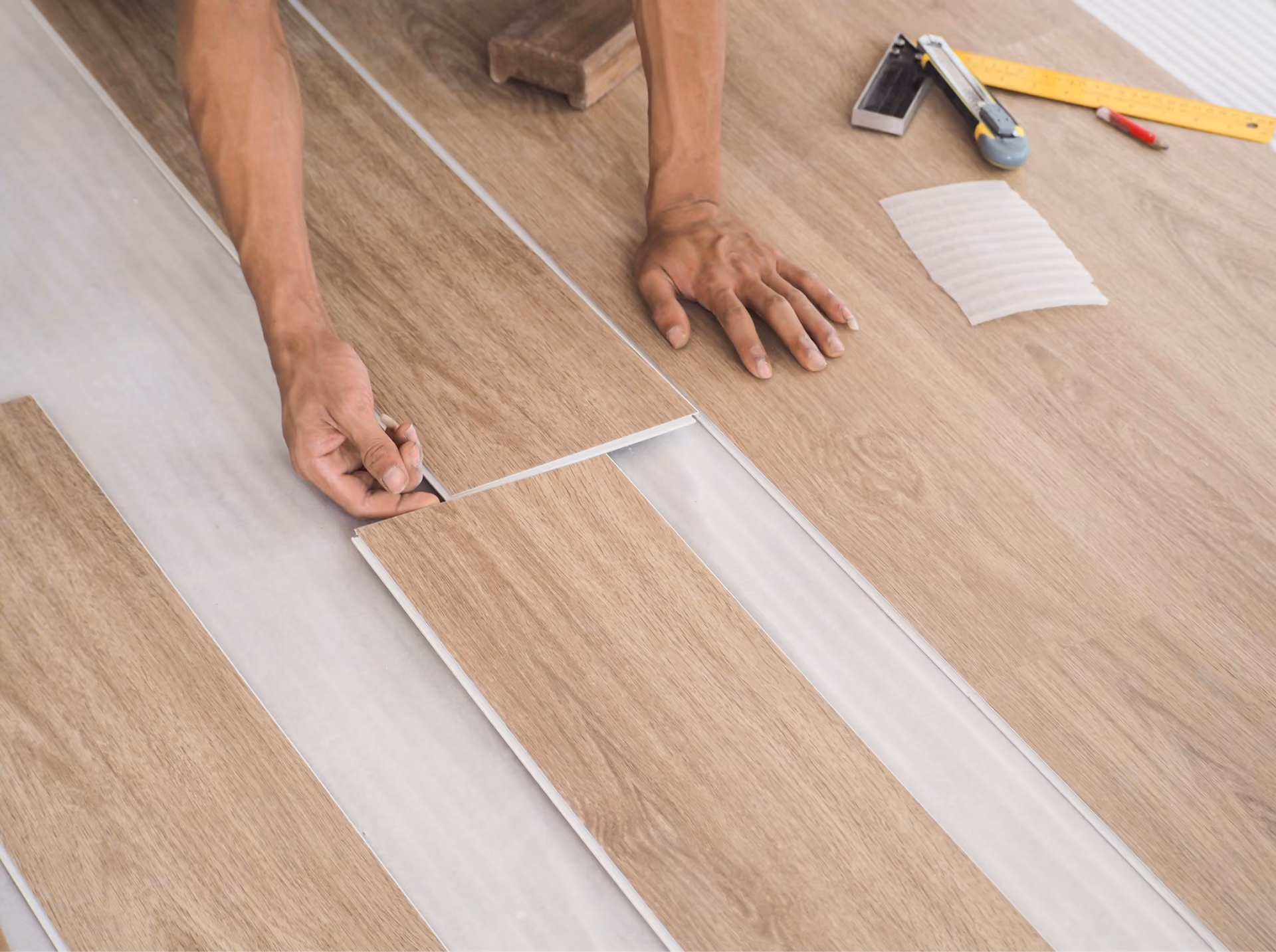 Installer fitting wood-look luxury vinyl plank flooring