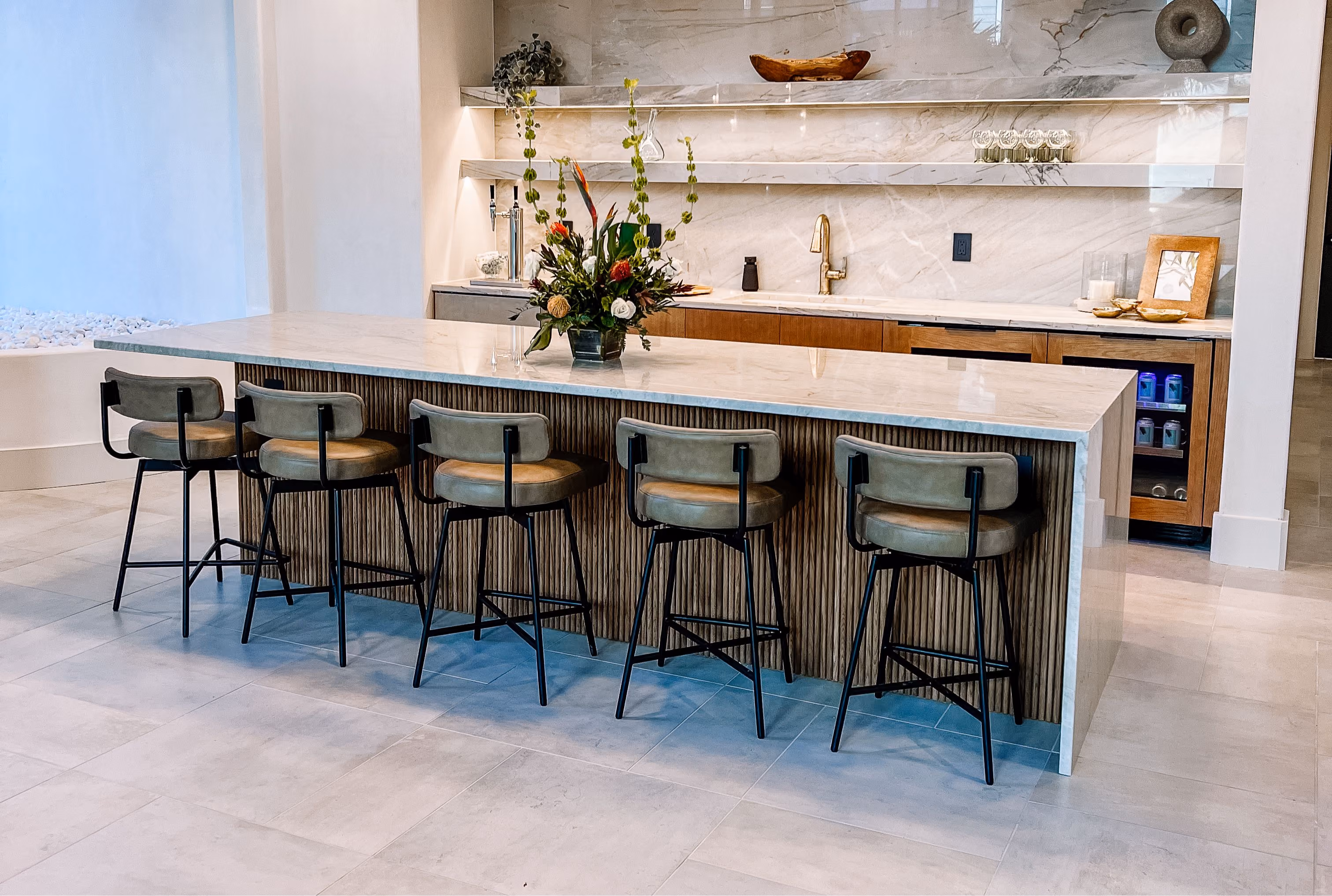 Kitchen with a waterfall stone island and matching stone backsplash
