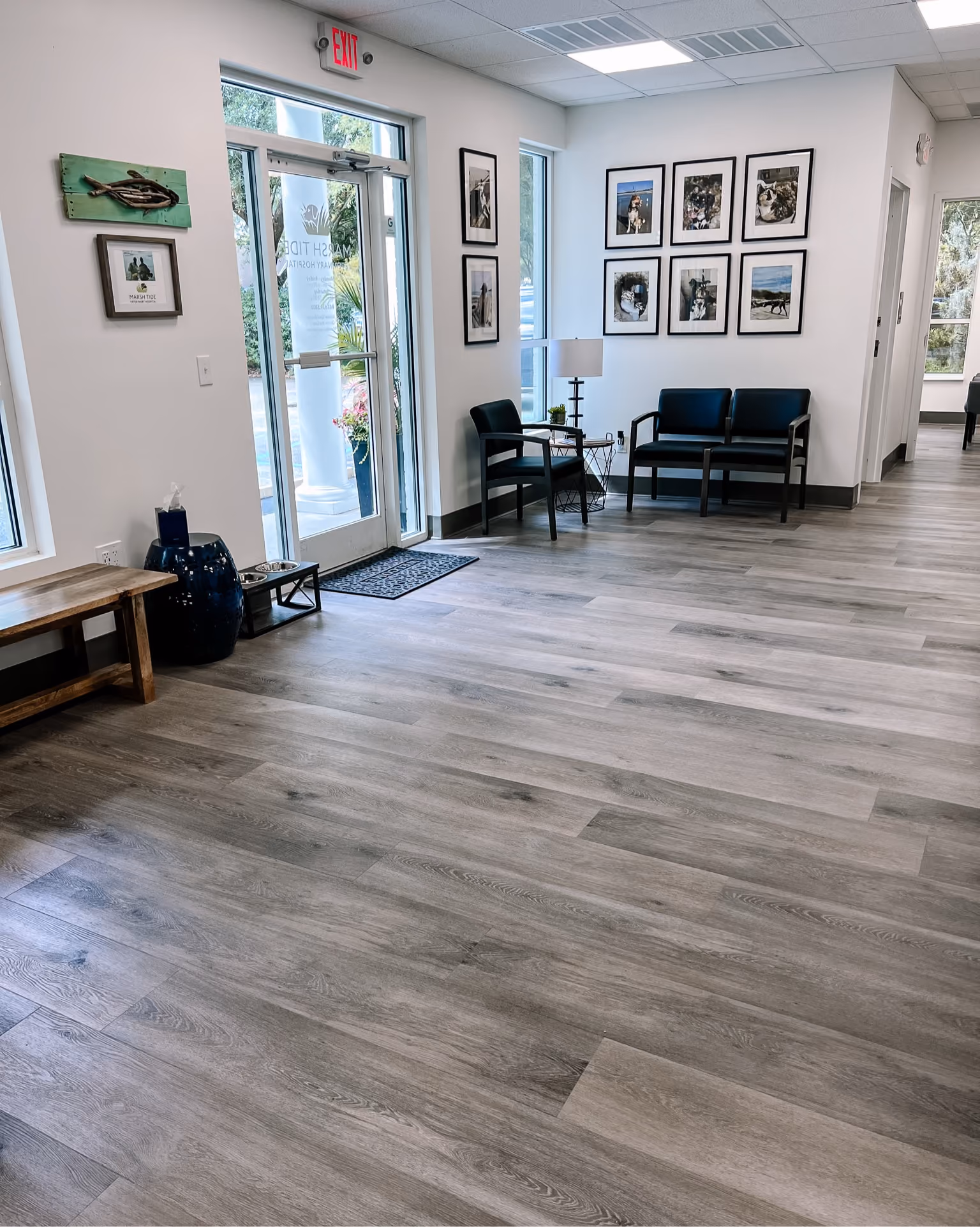 Hallway with gray wood-look vinyl plank flooring and a gallery wall