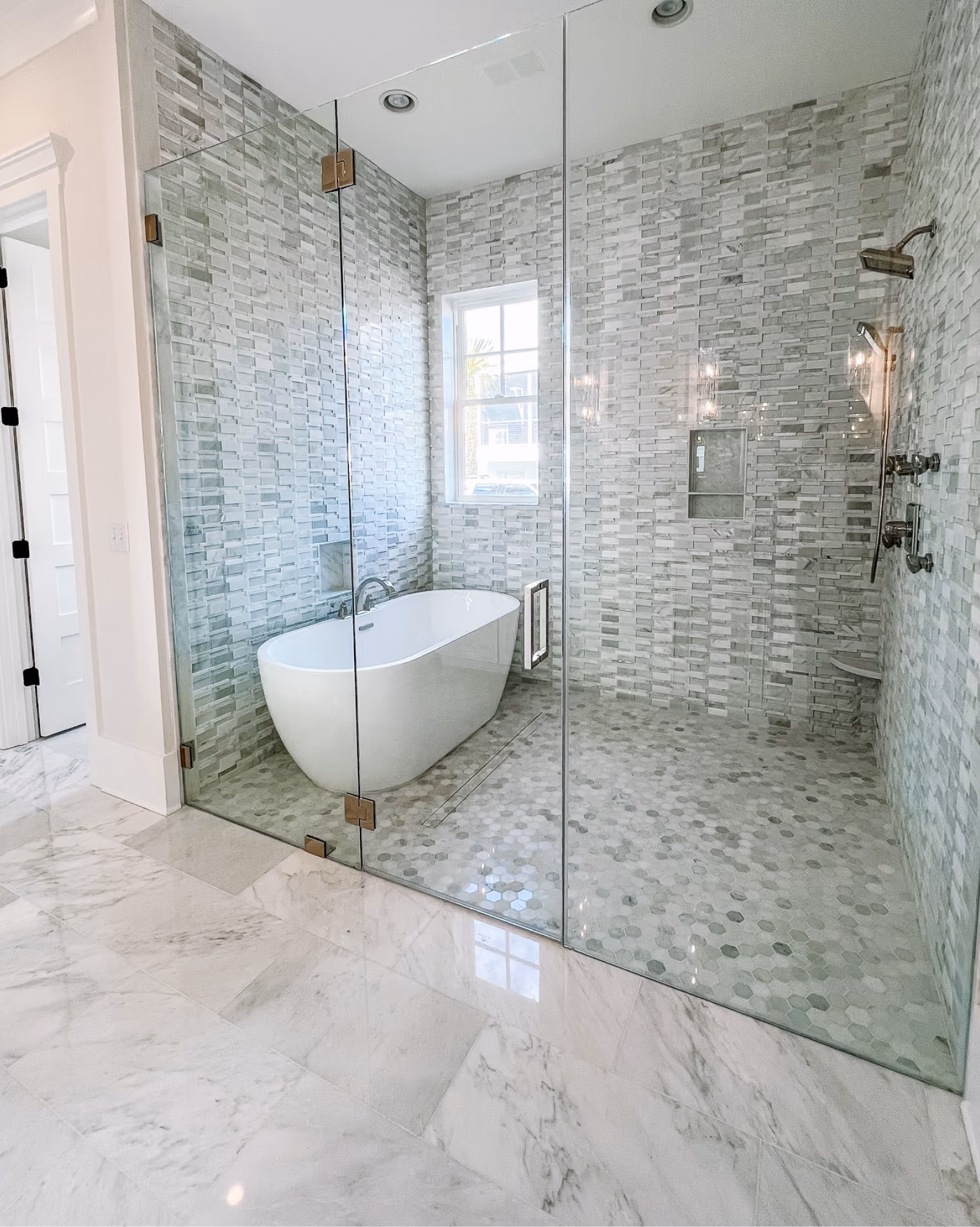 Bathroom with natural stone mosaic tile shower walls and a freestanding tub