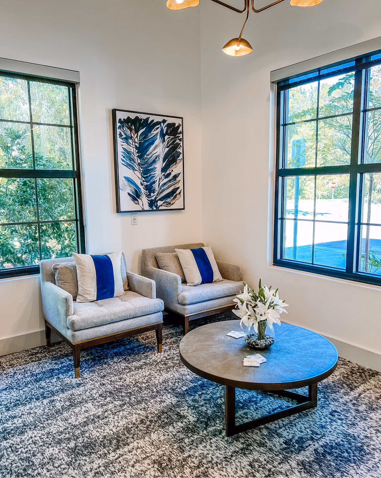 Sitting area with a blue and gray patterned area rug and gray armchairs