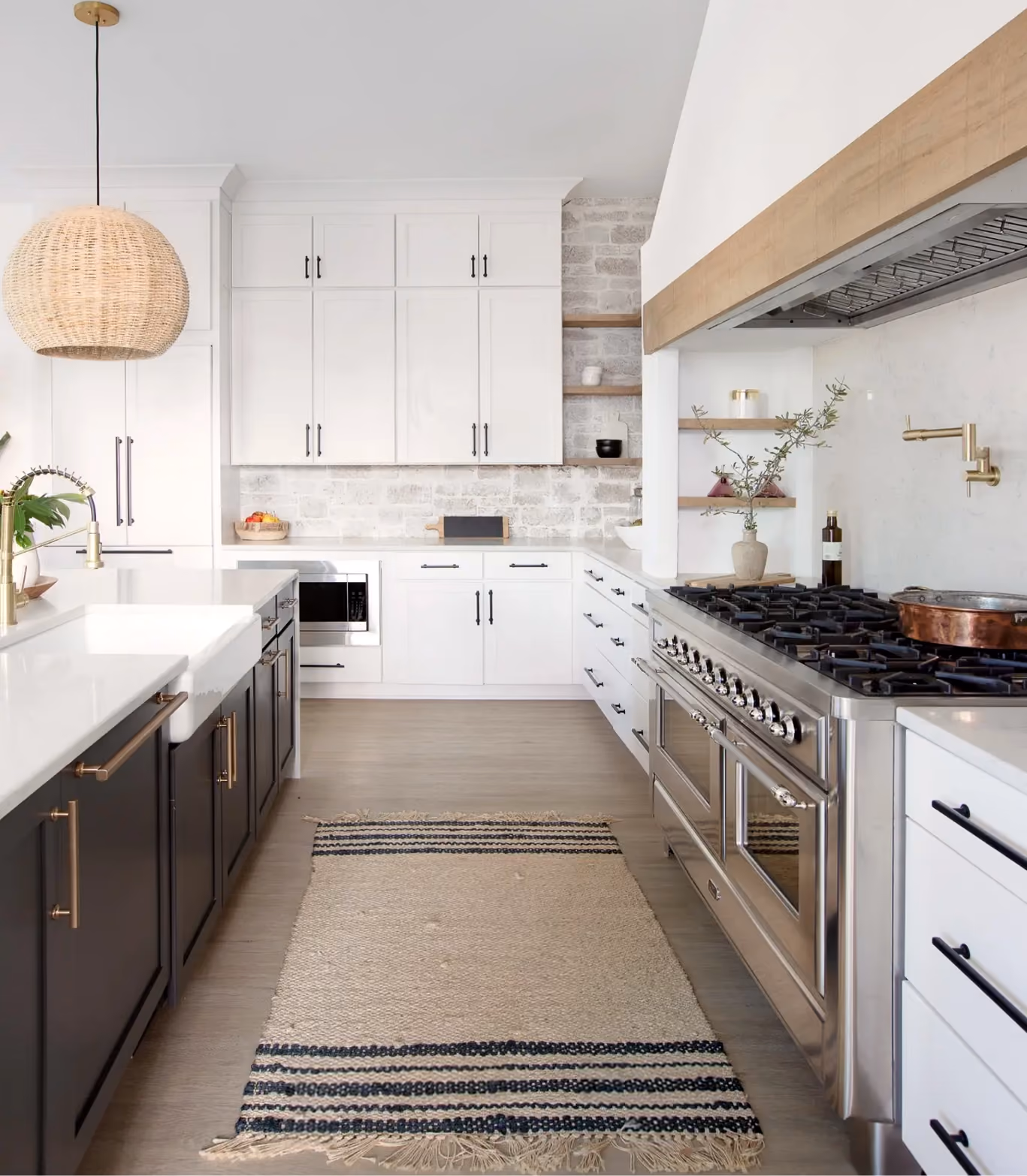 Kitchen with a navy island, white cabinetry, and hardwood flooring