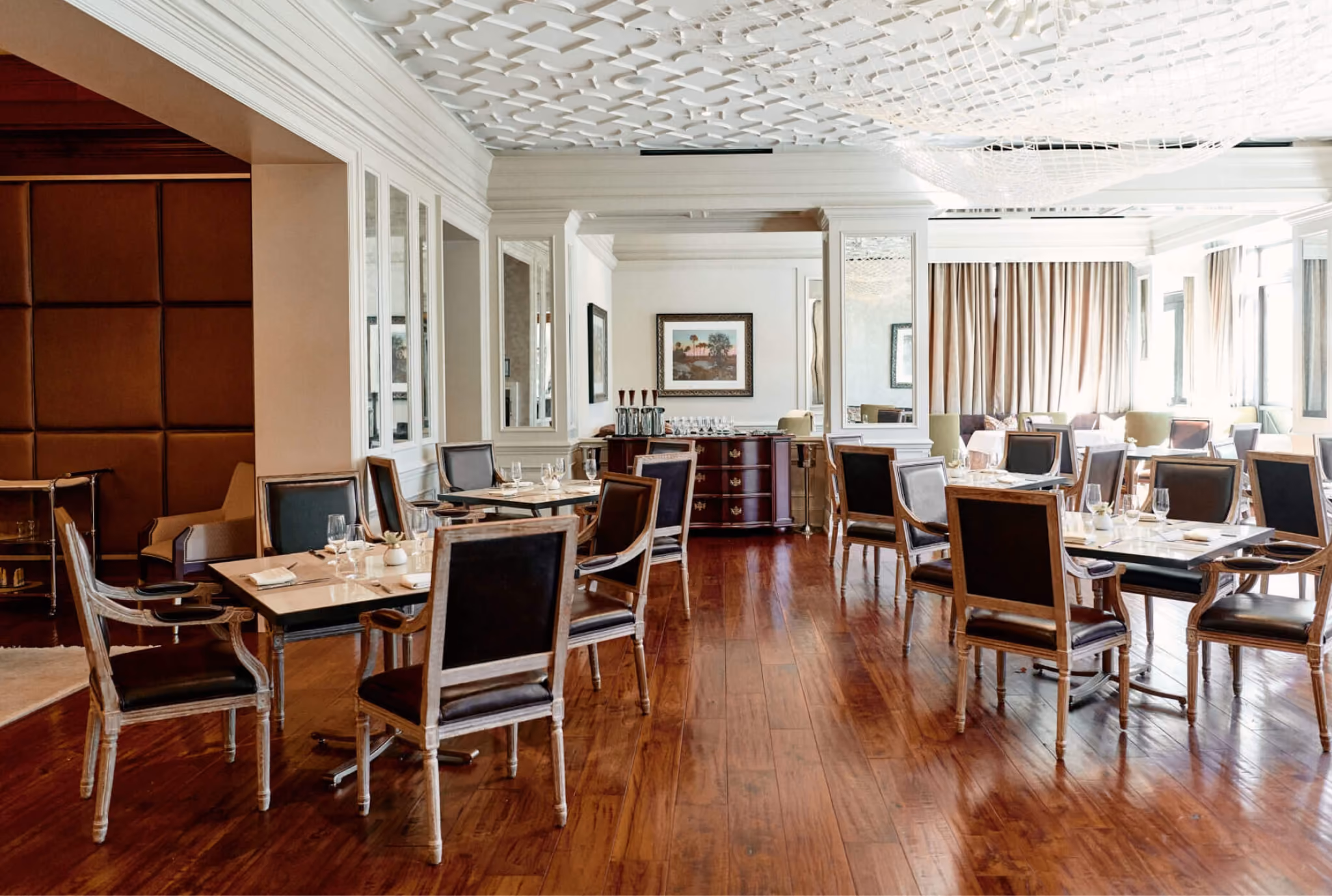 Dining room with dark reddish-brown hardwood flooring and an ornate ceiling