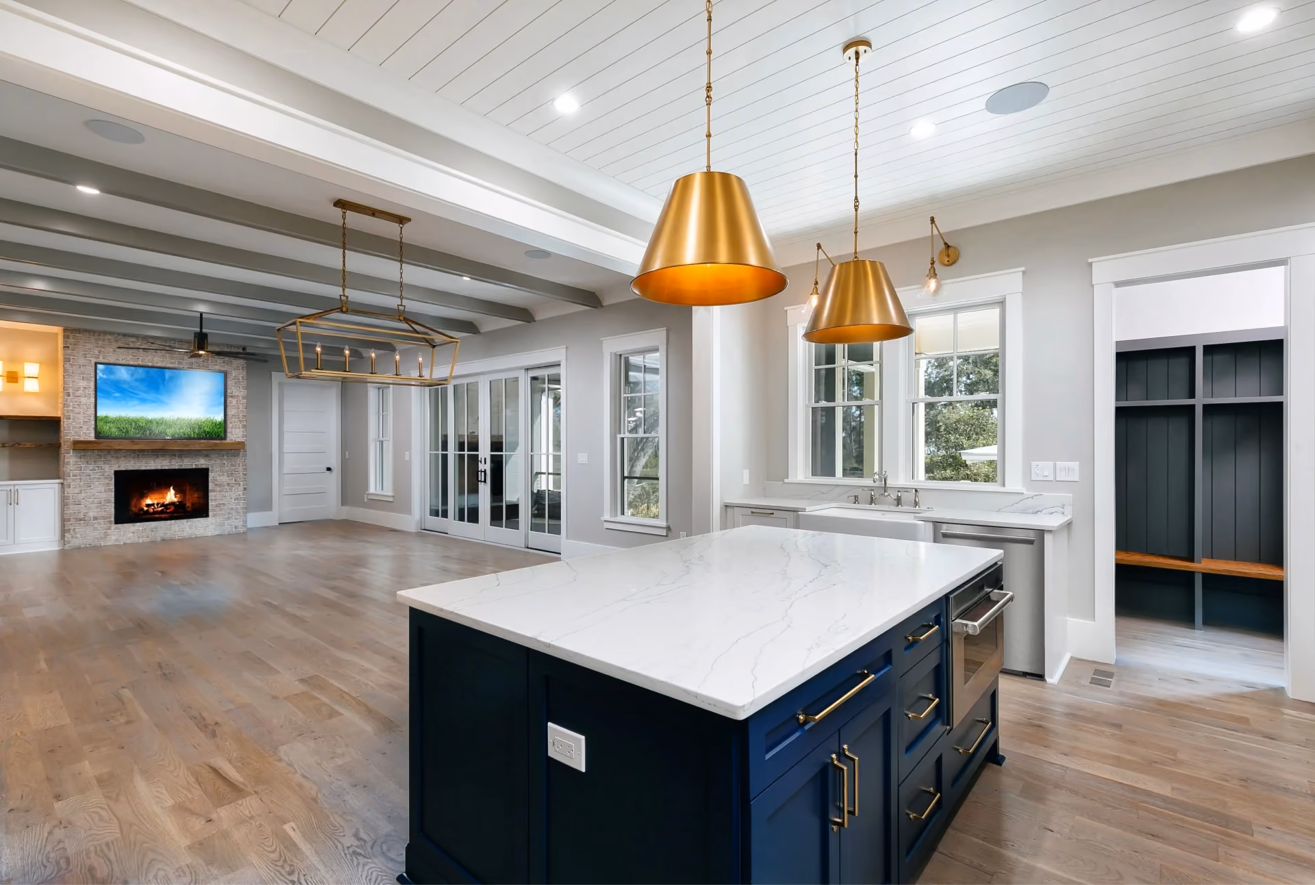 Open-concept kitchen and living area with wide-plank hardwood flooring and exposed beams