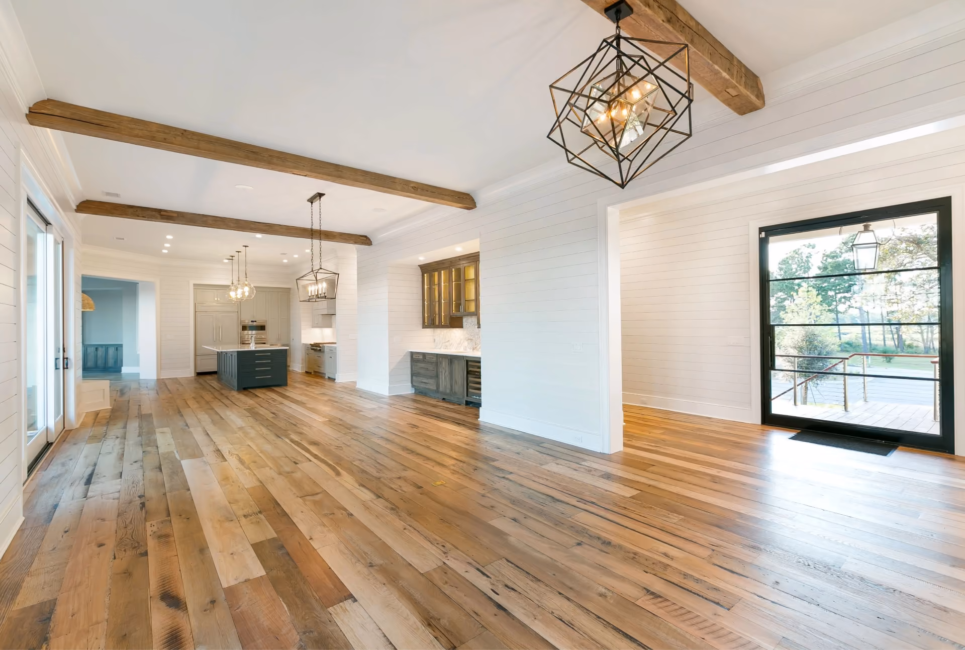 Living and dining space with wide-plank hardwood flooring and a beamed ceiling