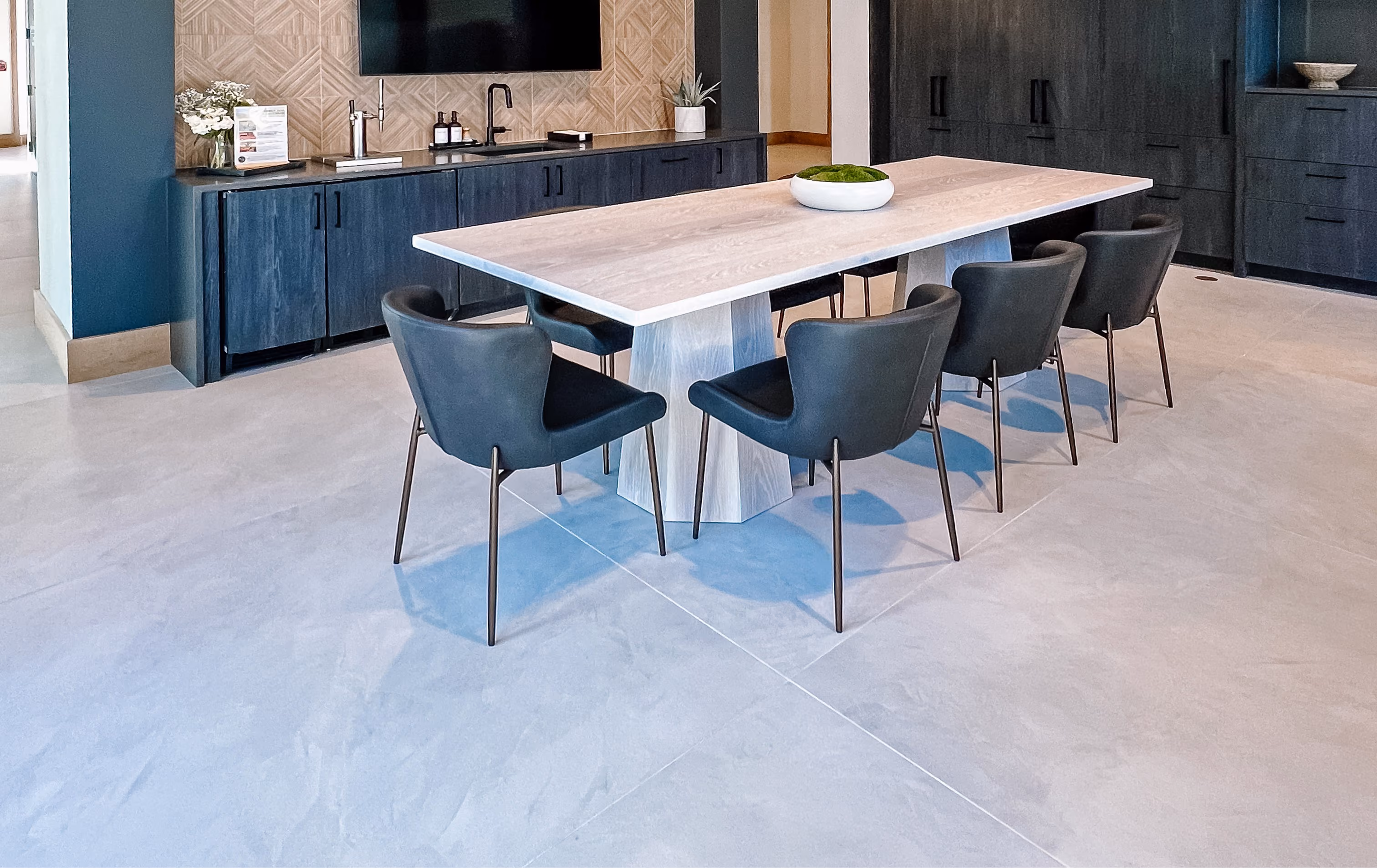 Community dining area with a long table, pendant lighting, and tile flooring