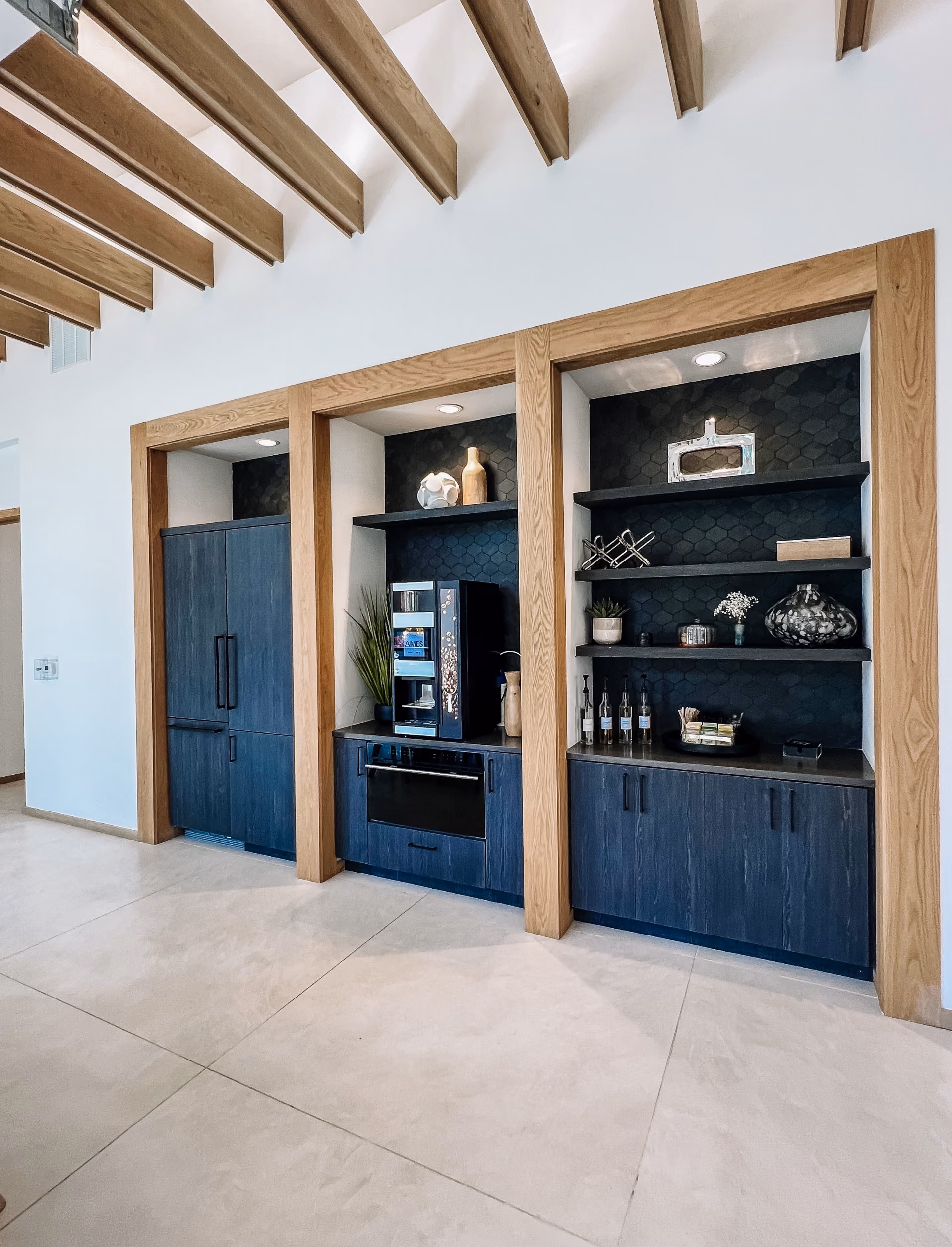 Community kitchen with built-in dark cabinetry and tile flooring