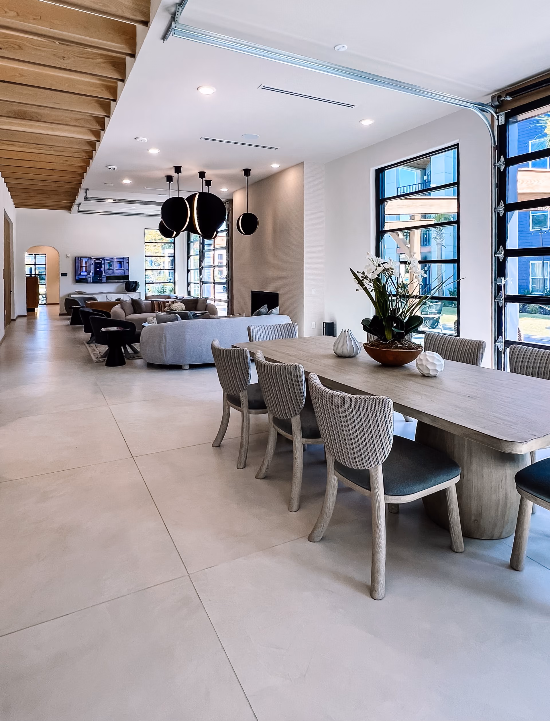 Community dining hall with a long table, seating, and tile flooring