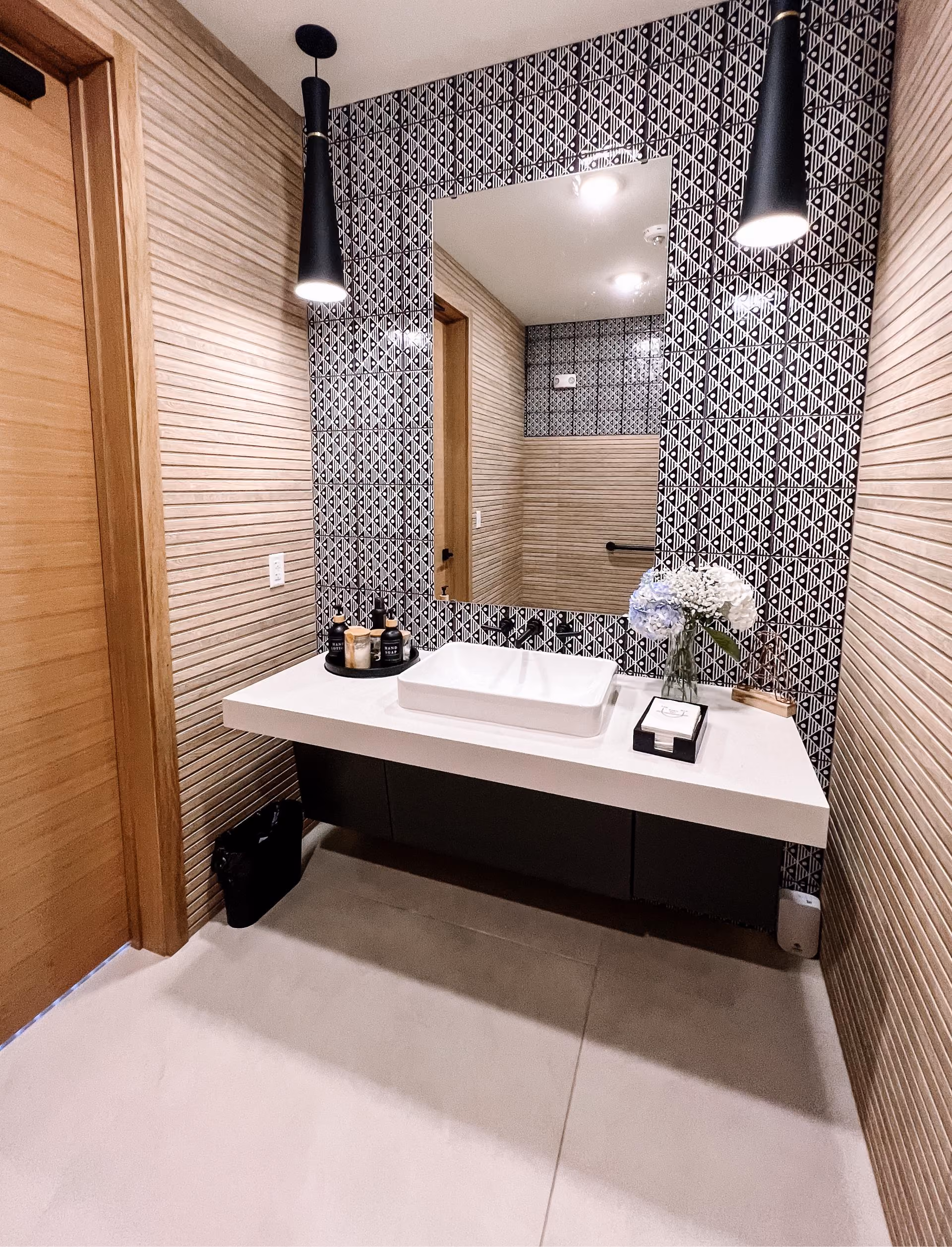 Bathroom vanity with patterned wall tile and mosaic tile flooring