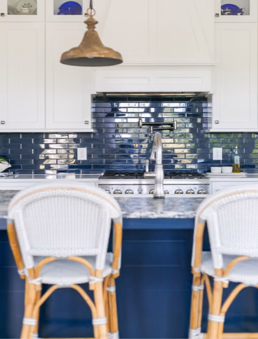 Kitchen with navy cabinets, blue glass tile backsplash, and hardwood flooring