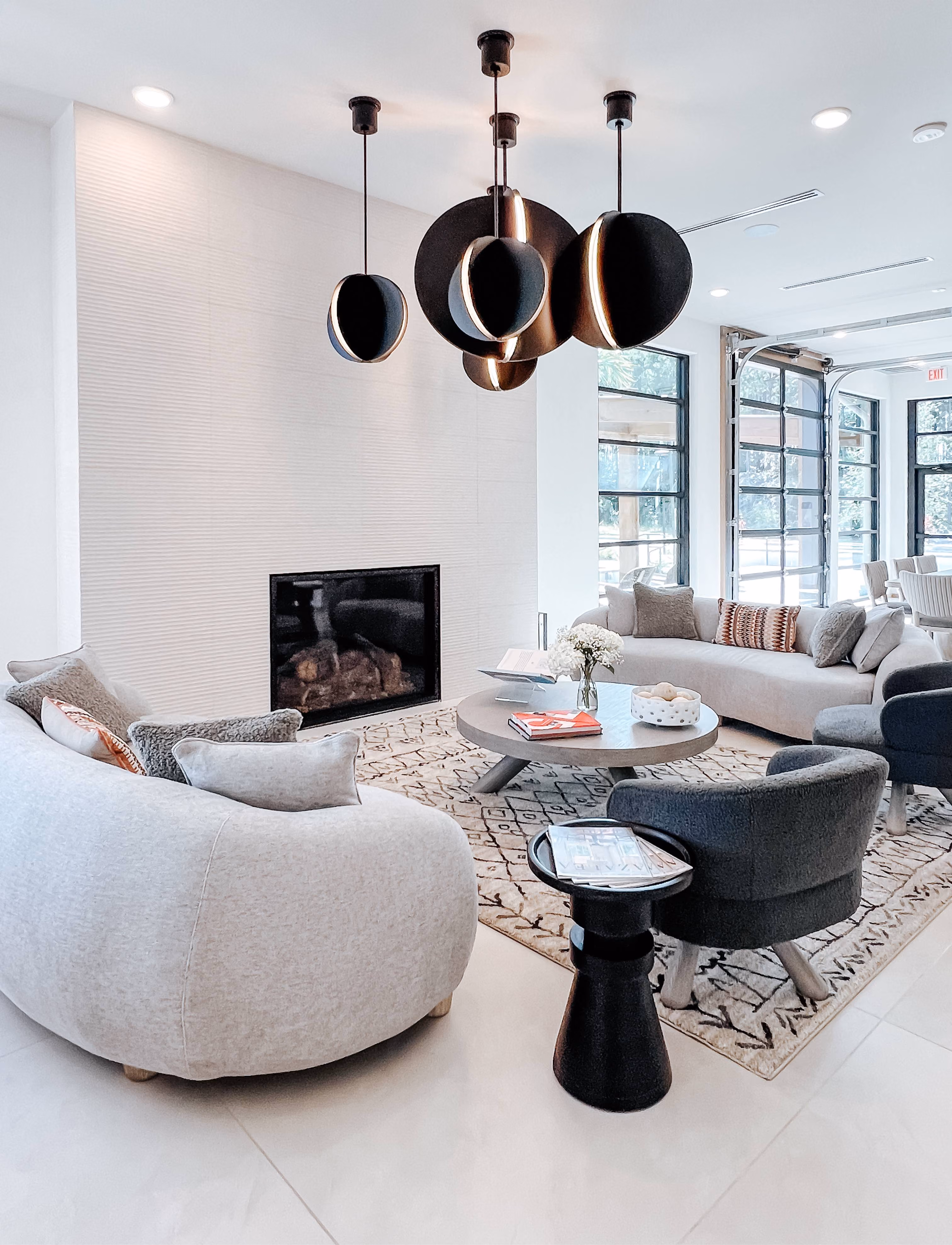 Community lounge with a fireplace, sectional sofa, and gray tile flooring
