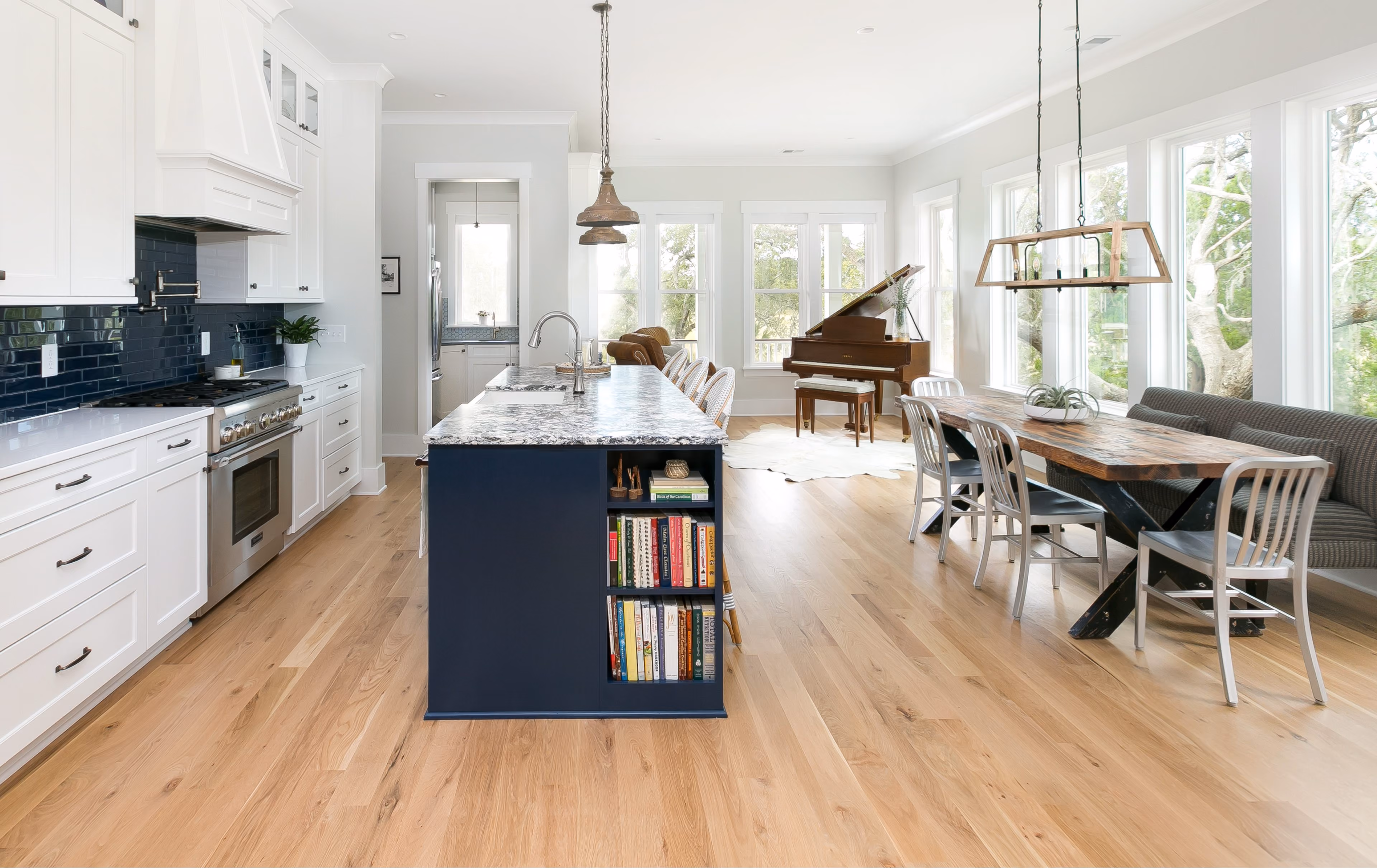 Kitchen with a navy island, dining area, and hardwood flooring