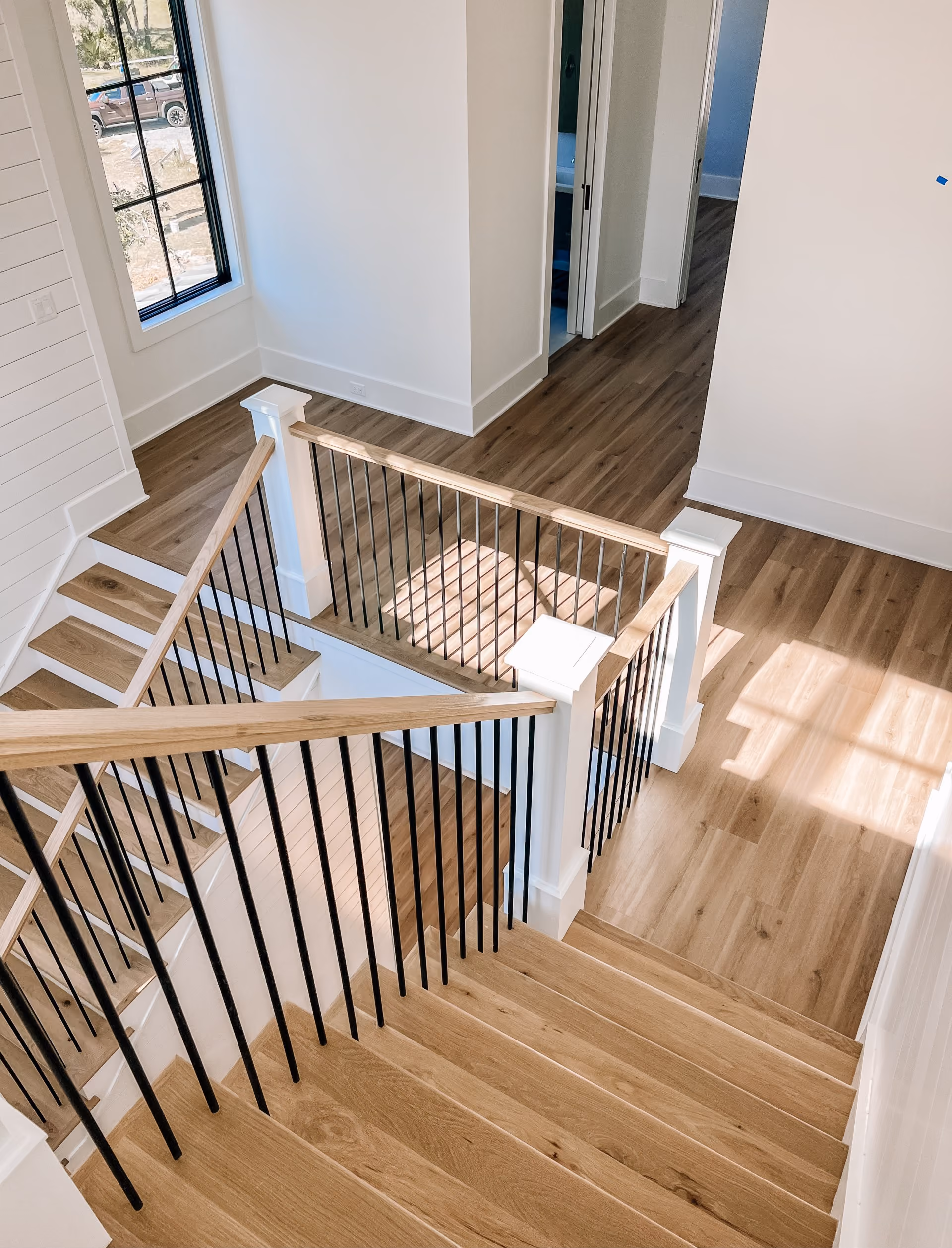 Overhead view of a staircase and loft with hardwood flooring