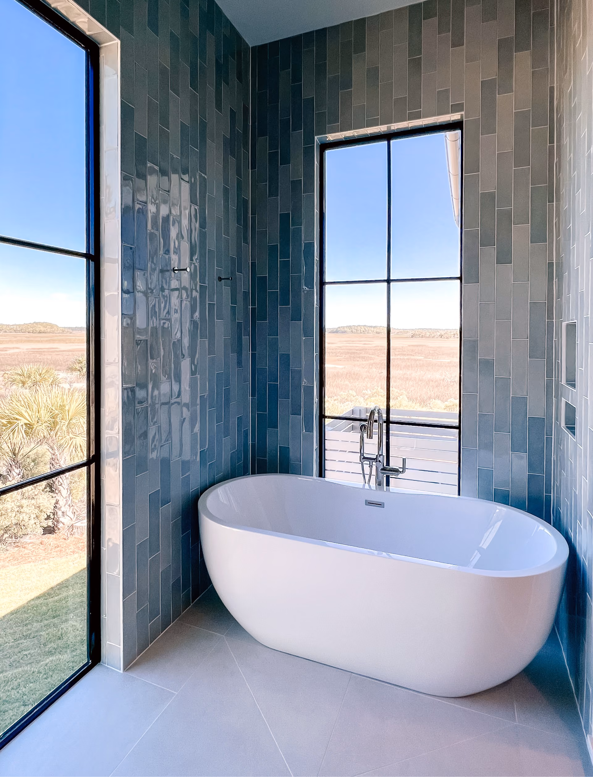 Bathroom with a freestanding tub and teal tile walls
