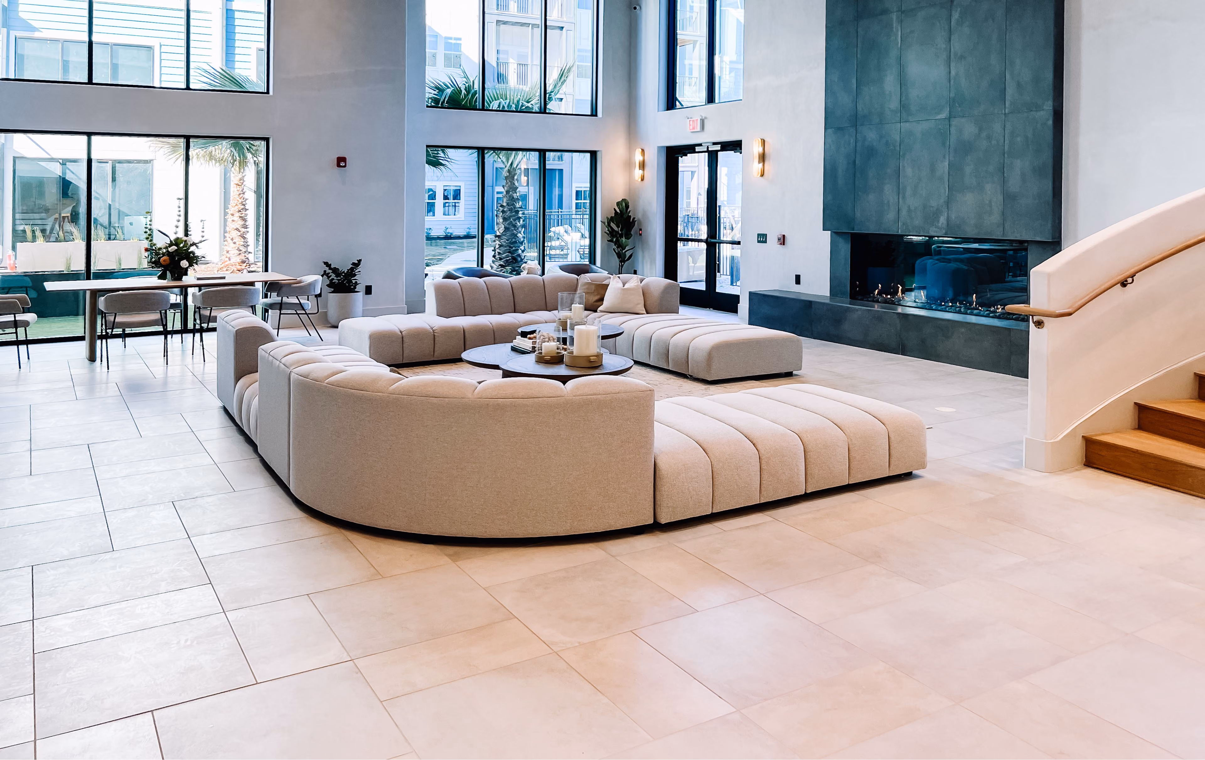 Lounge with a stone fireplace, sectional seating, and tile flooring