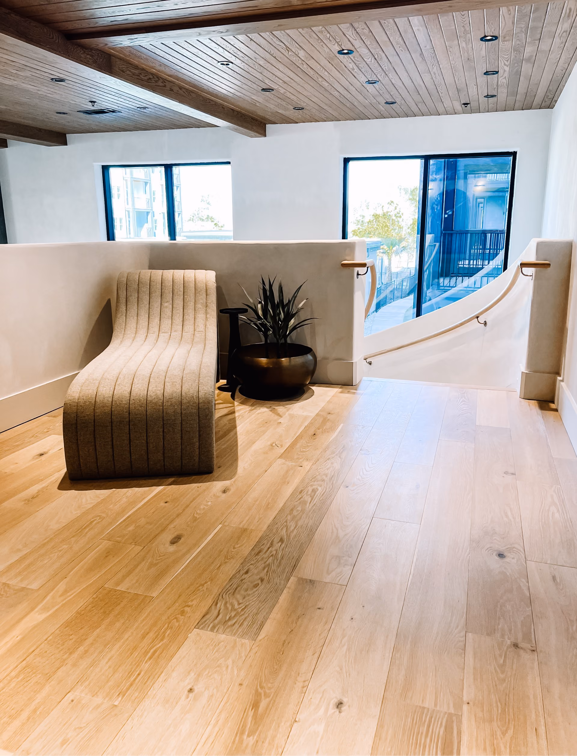 Lounge nook with a textured chair on wood-look plank flooring