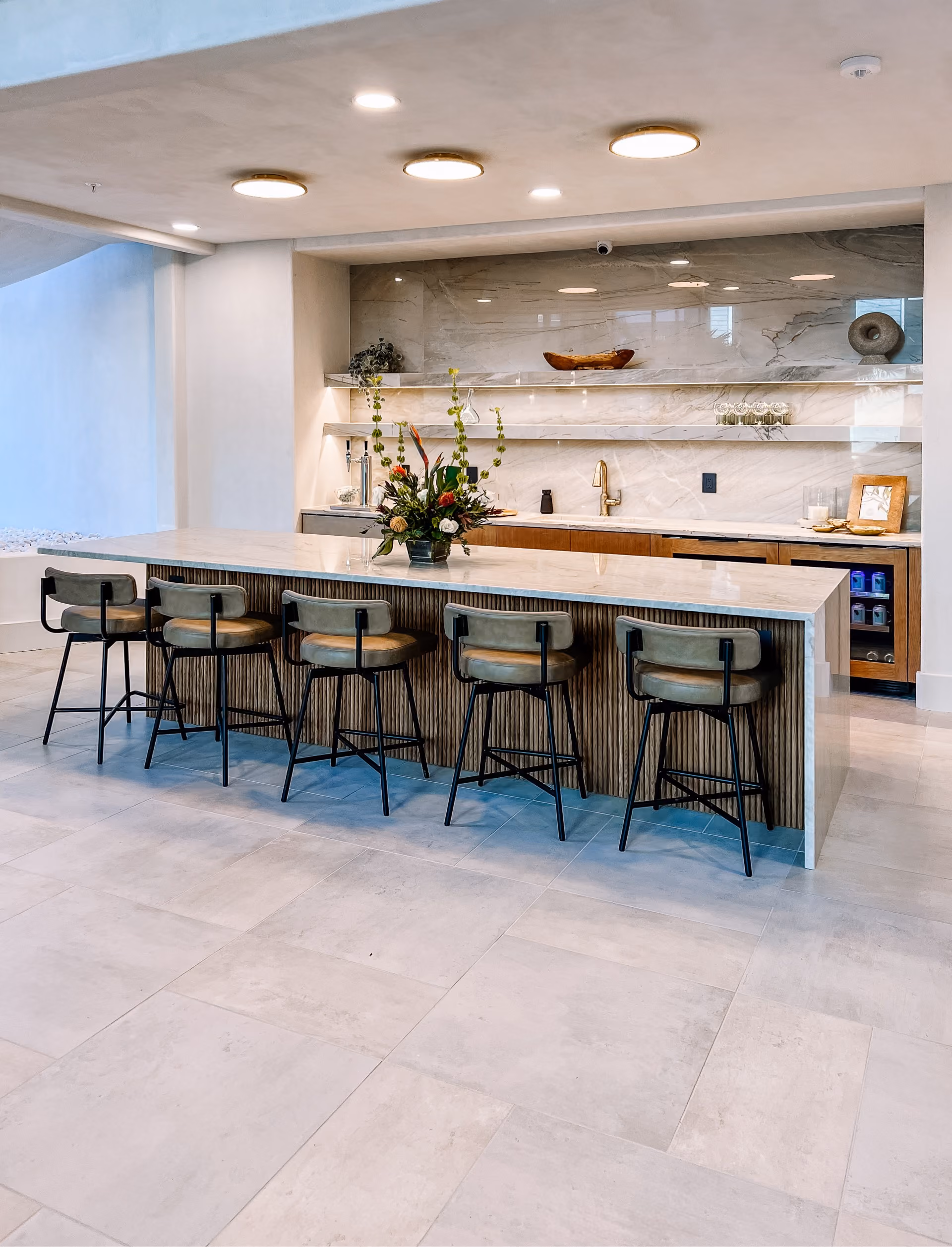 Kitchen bar with a marble countertop island and stone tile flooring