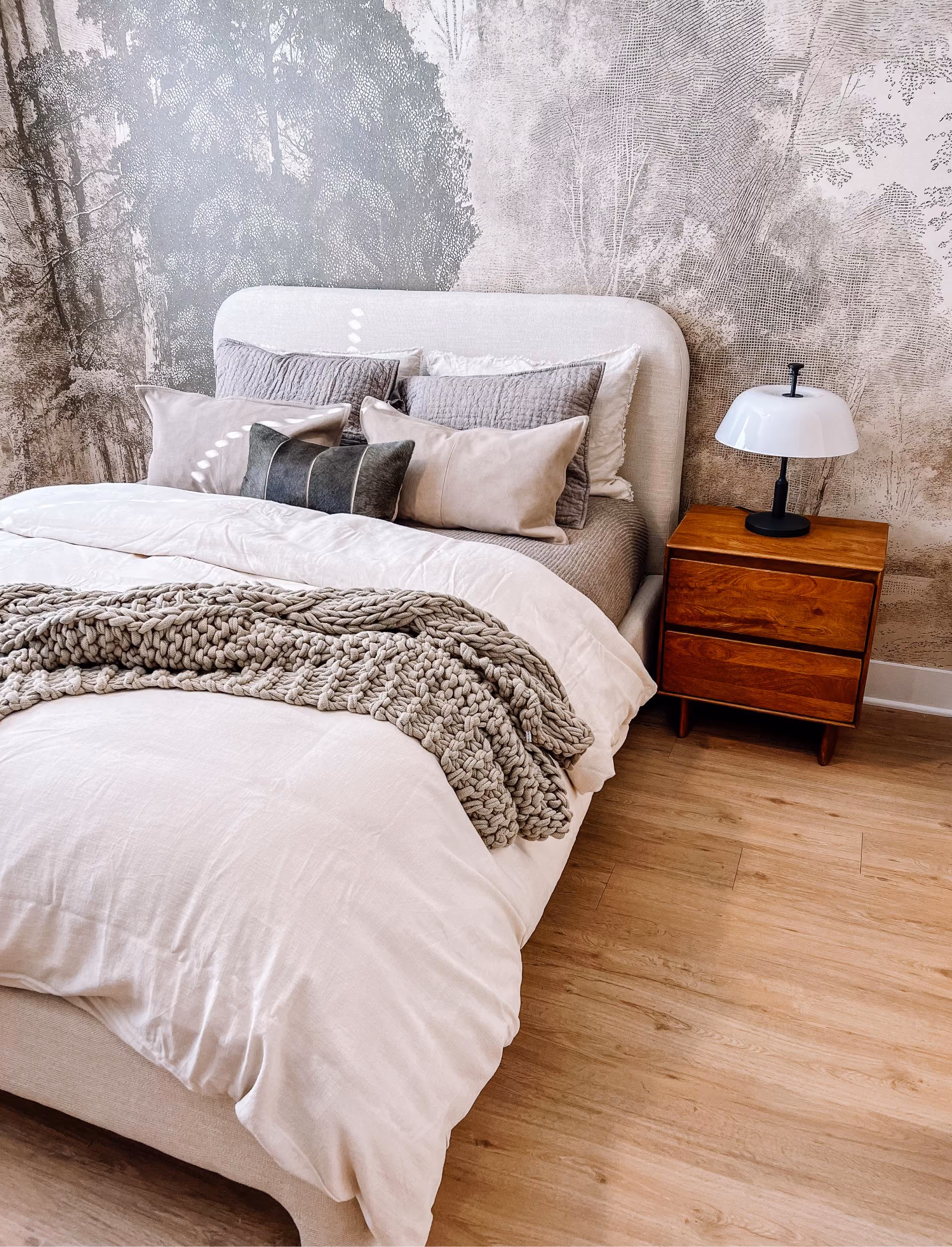 Bedroom with an upholstered headboard and wood-look flooring