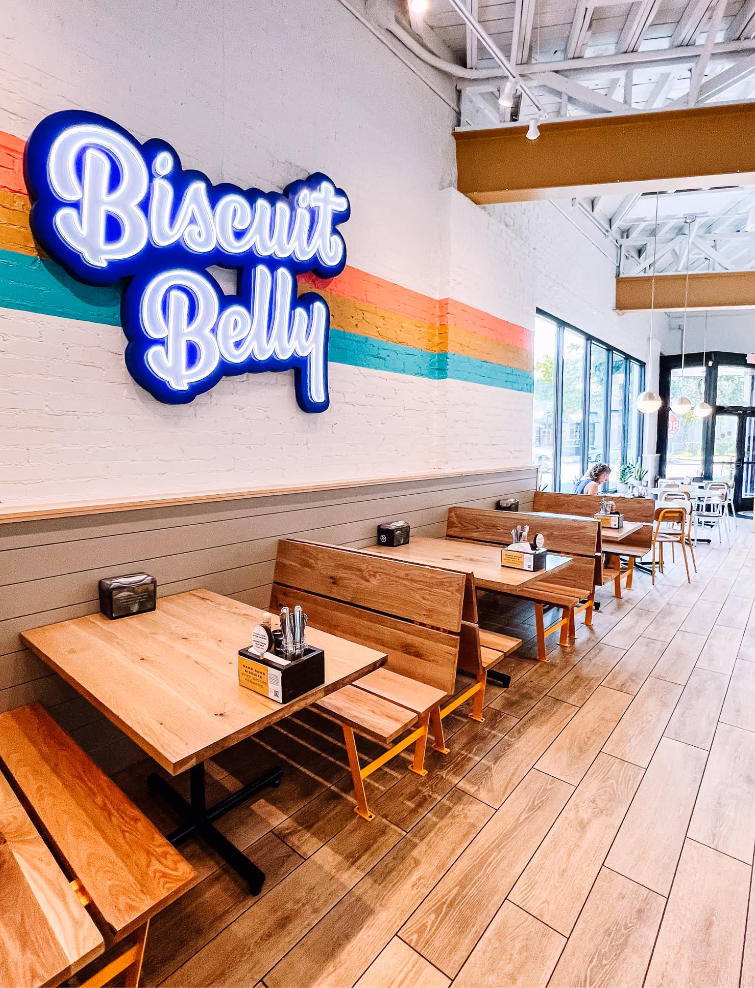 Biscuit Belly neon sign above dining booths on patterned tile flooring