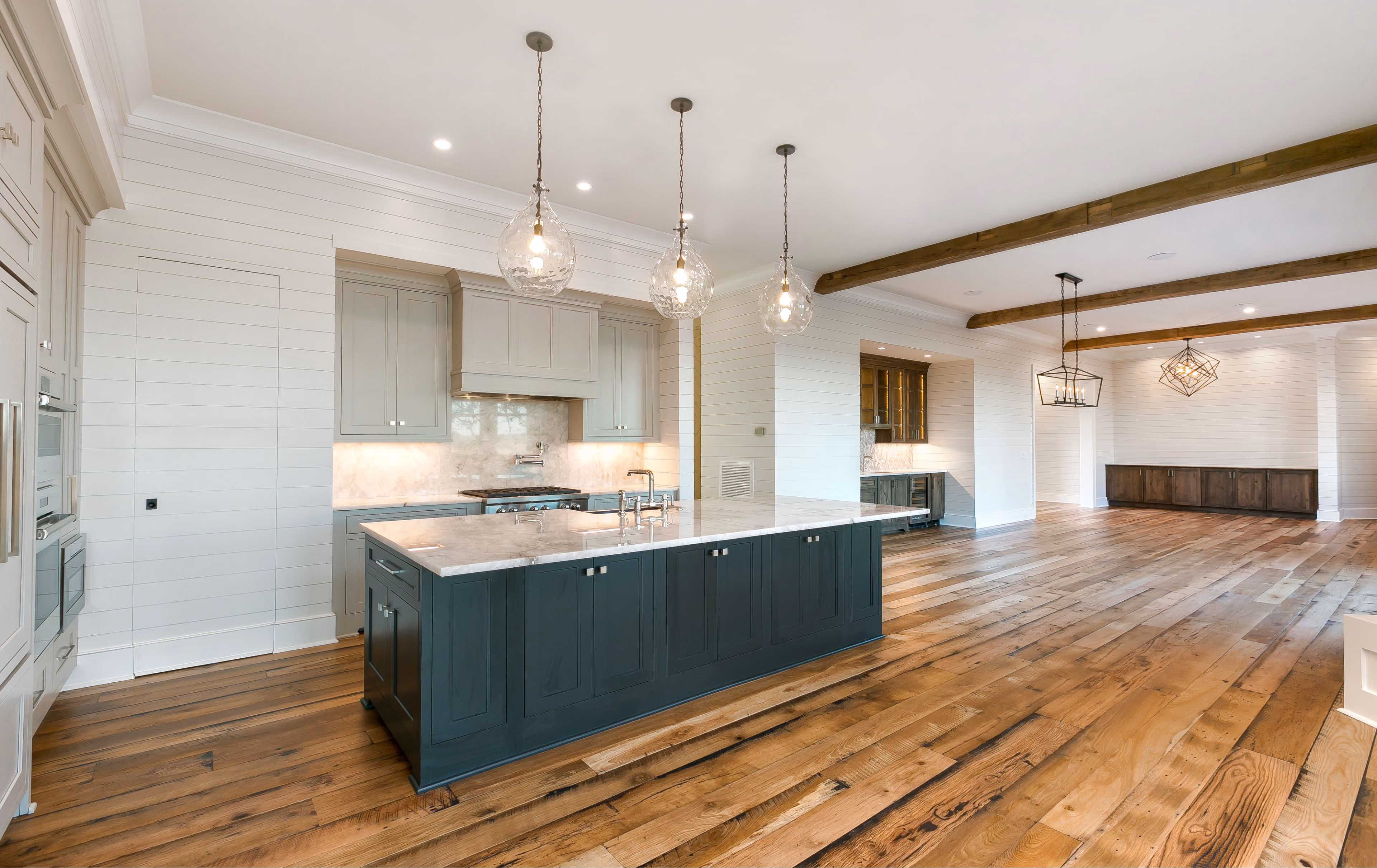 Kitchen with a navy island and hardwood flooring
