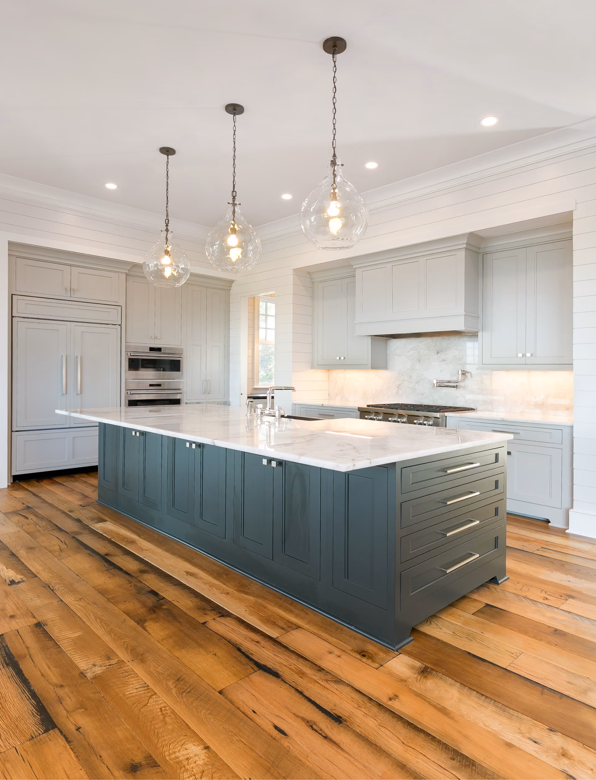 Kitchen with a navy island and hardwood flooring