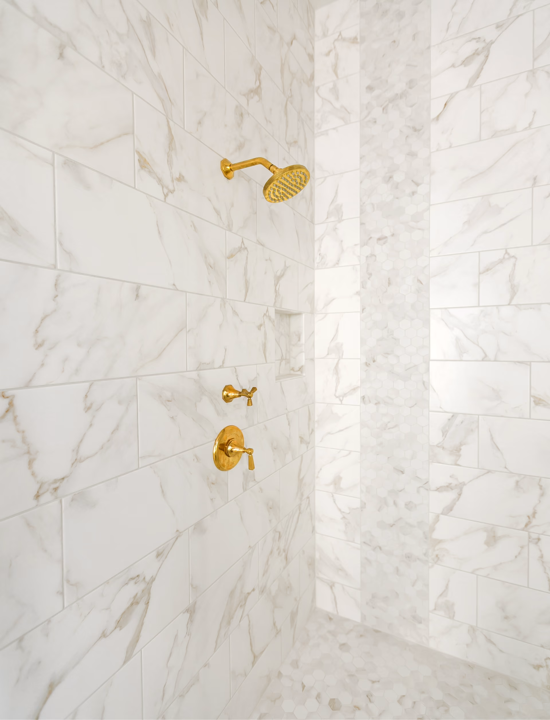 Marble tile shower with gold fixtures