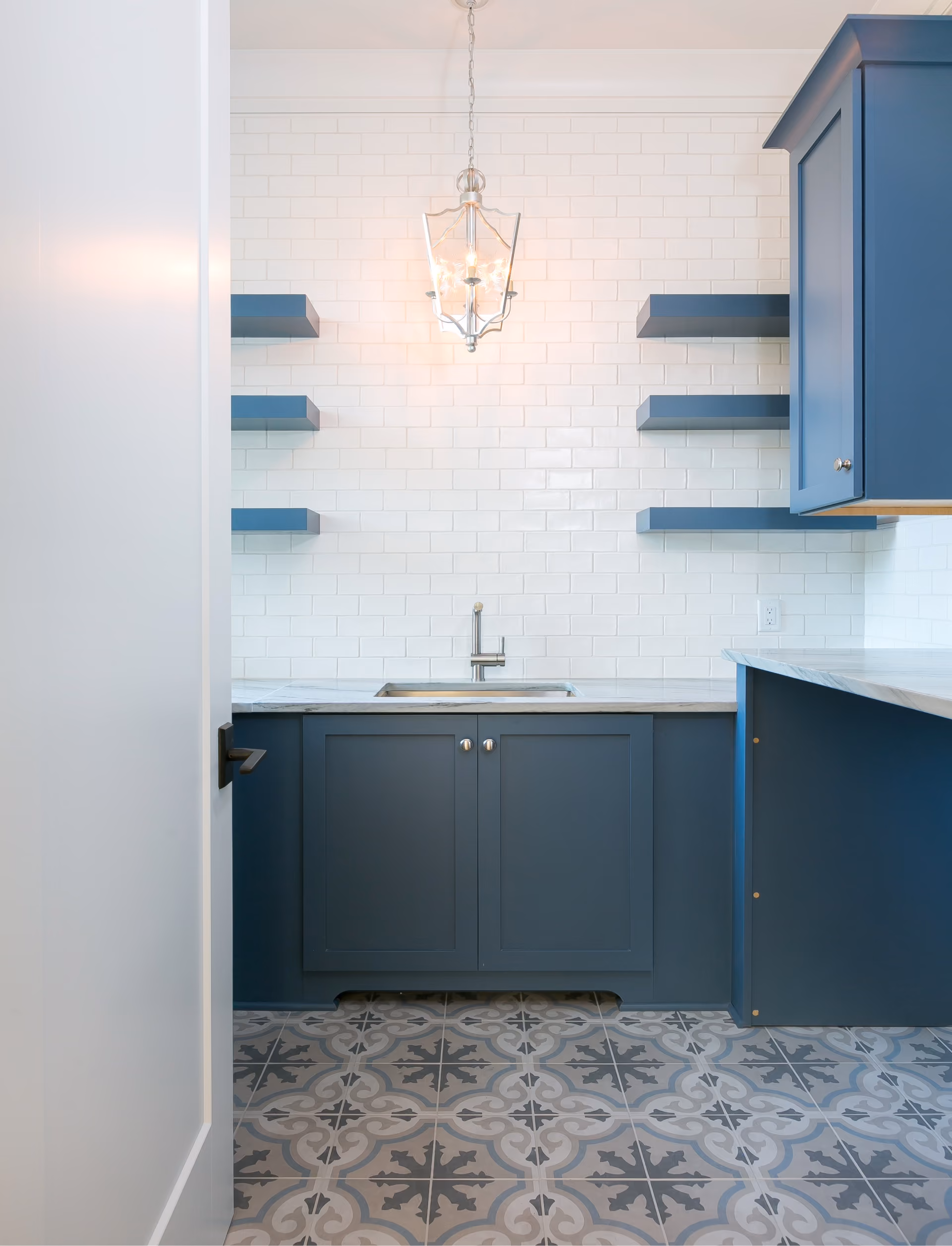 Kitchen with navy cabinetry and white subway tile backsplash