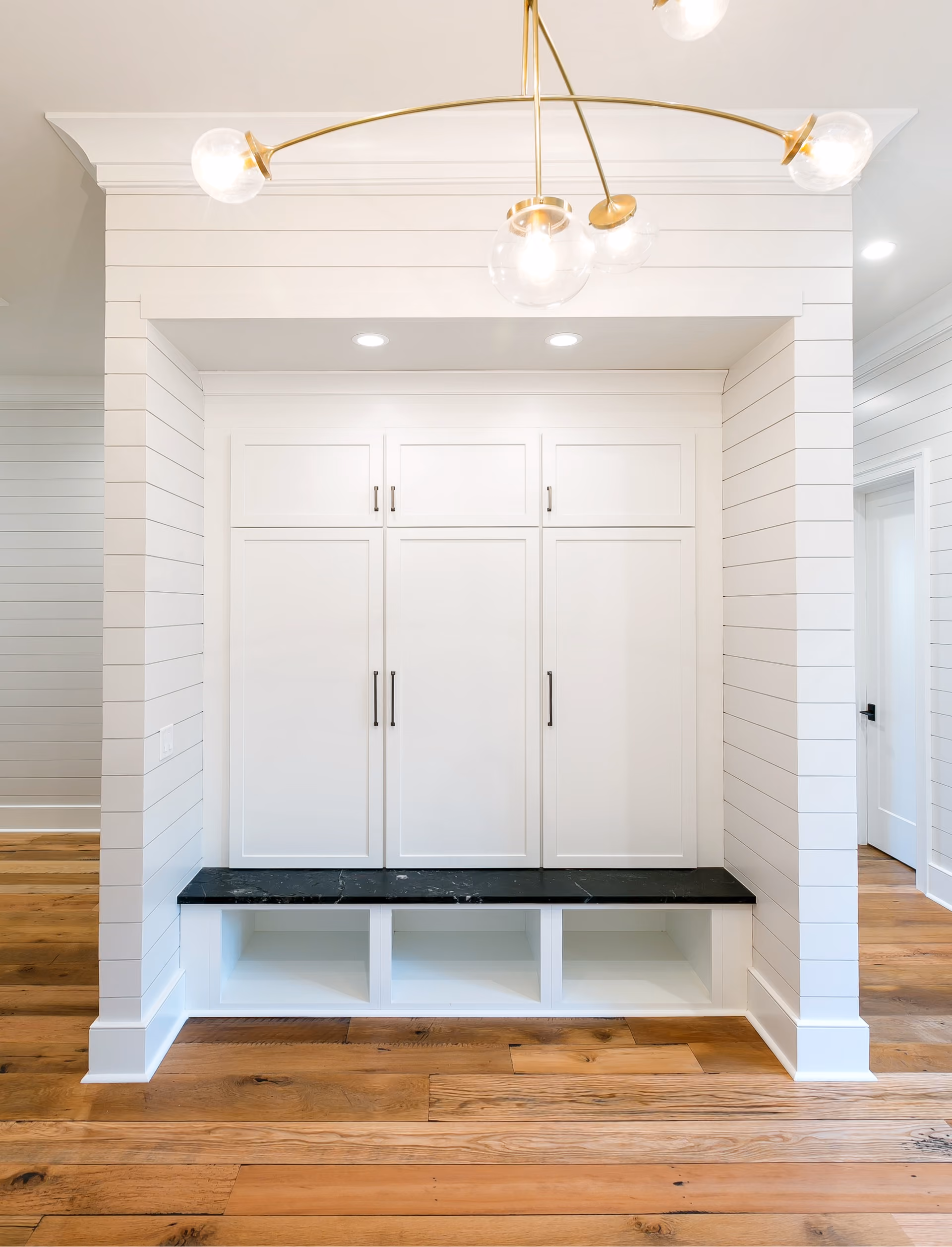Mudroom with white built-in cabinetry and a bench