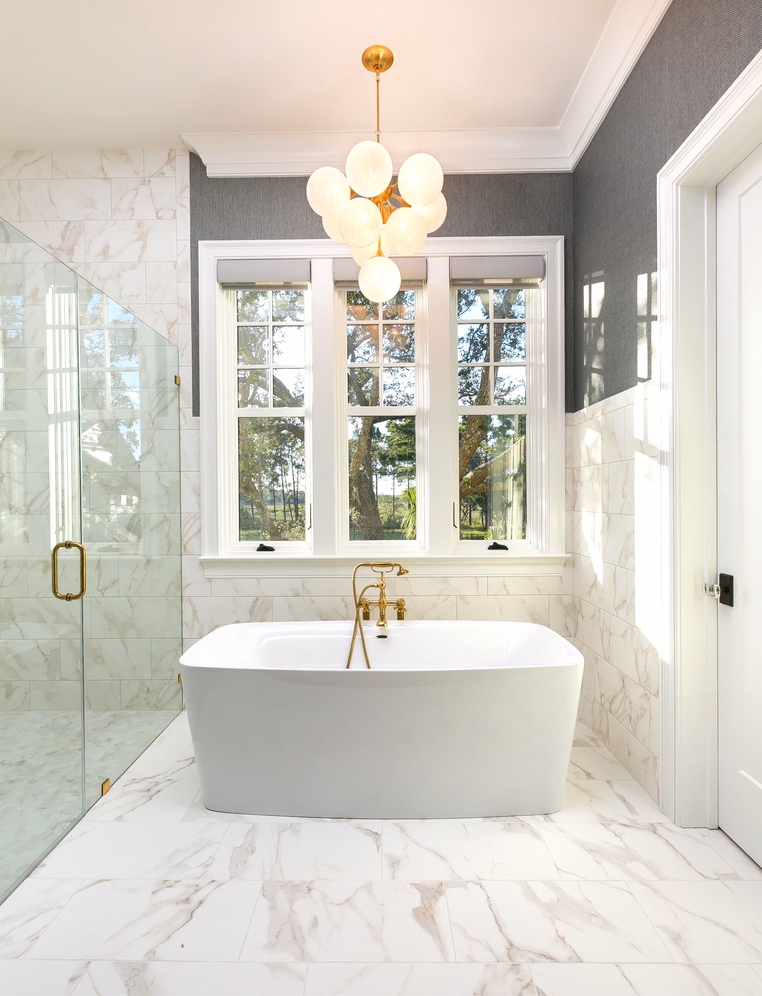 Bathroom with a freestanding tub and marble tile flooring