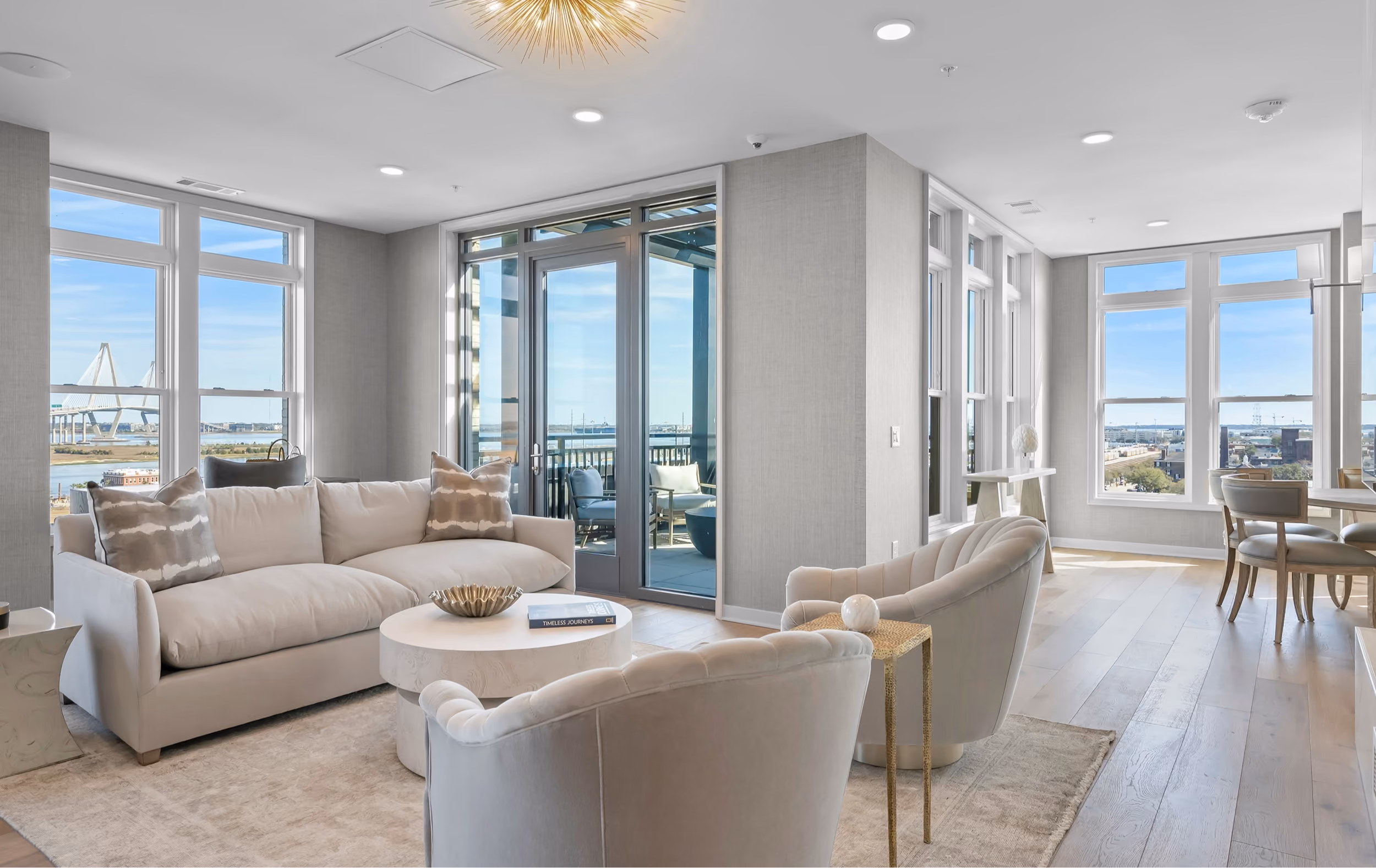 Living room with sofas, large windows, and wood-look flooring