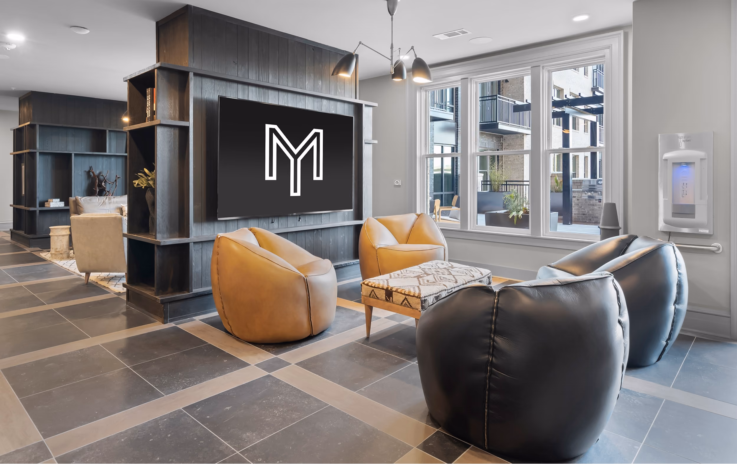 Lounge with a large TV, leather chairs, and patterned tile flooring