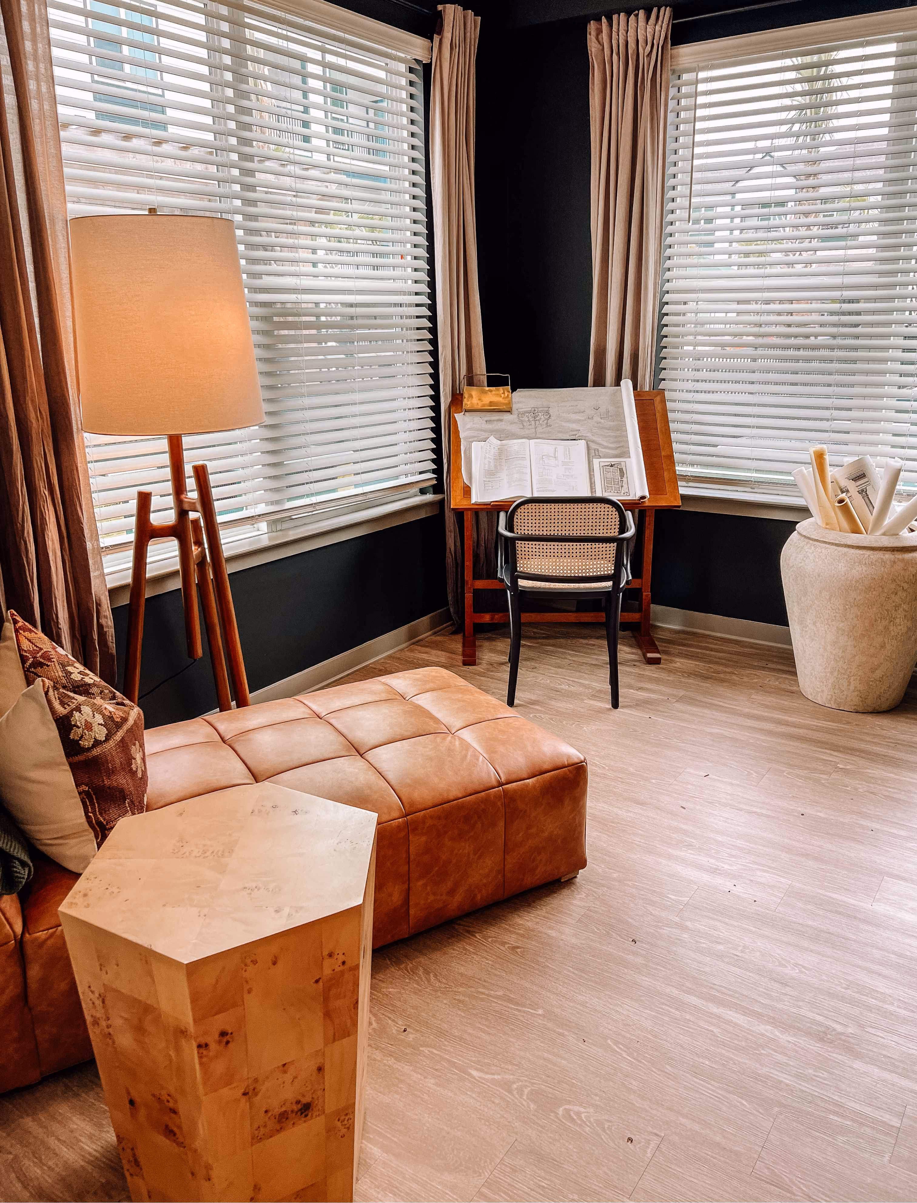 Lounge seating area with a leather ottoman on wood-look flooring