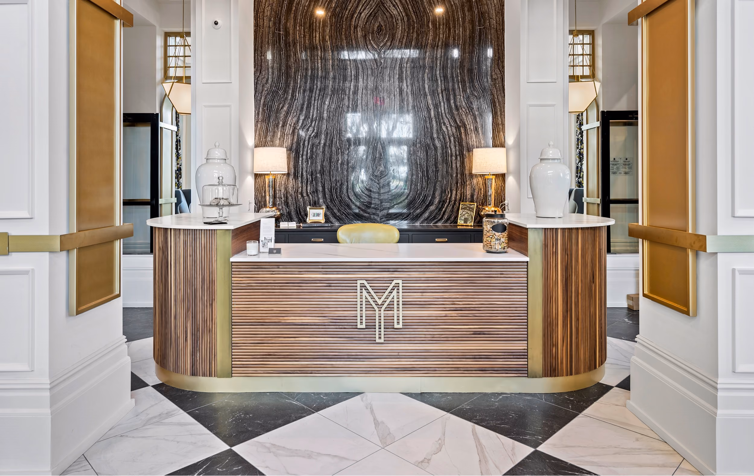 Lobby reception desk with a decorative wall feature and patterned tile flooring