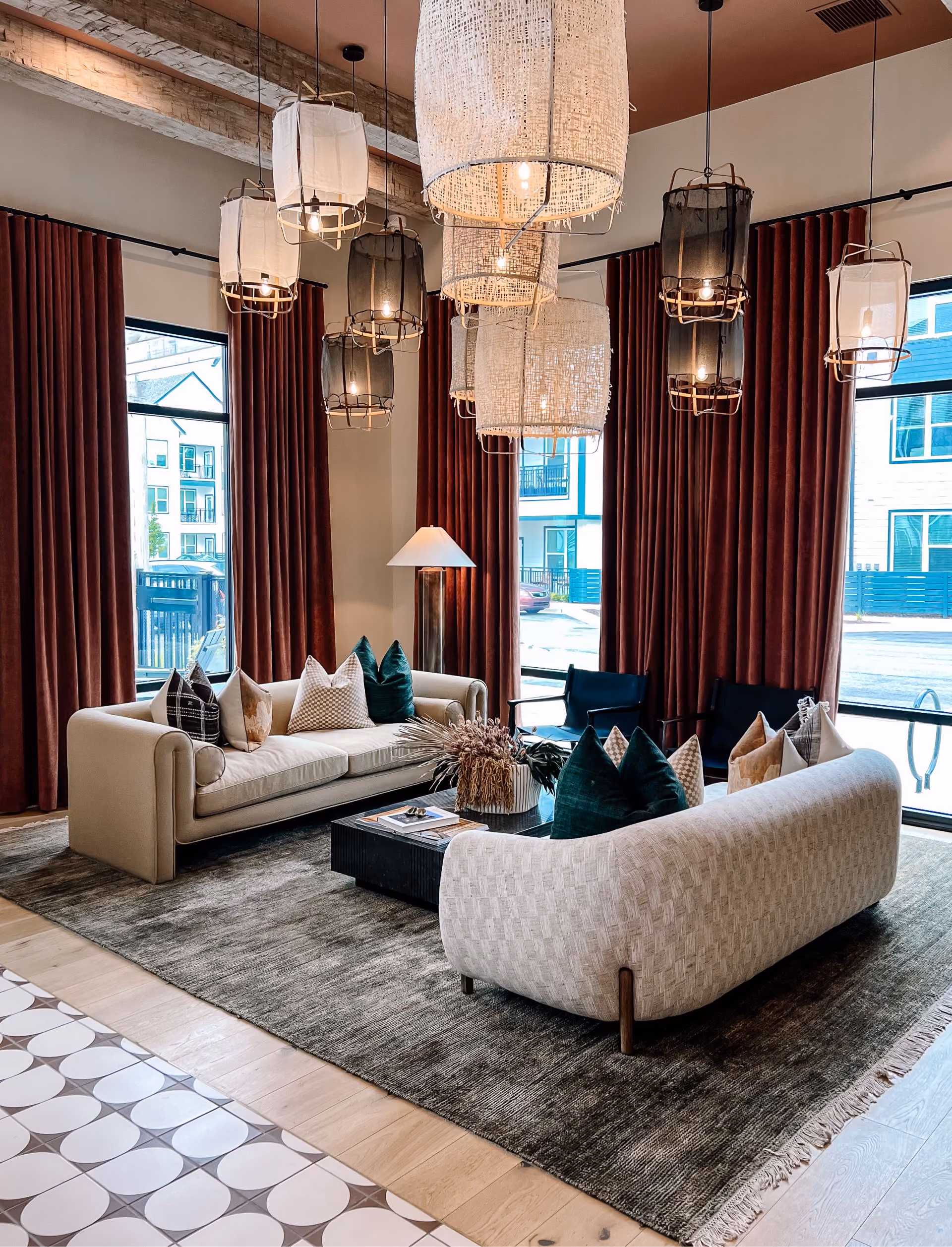 Living room with sofas, curtains, and patterned tile flooring