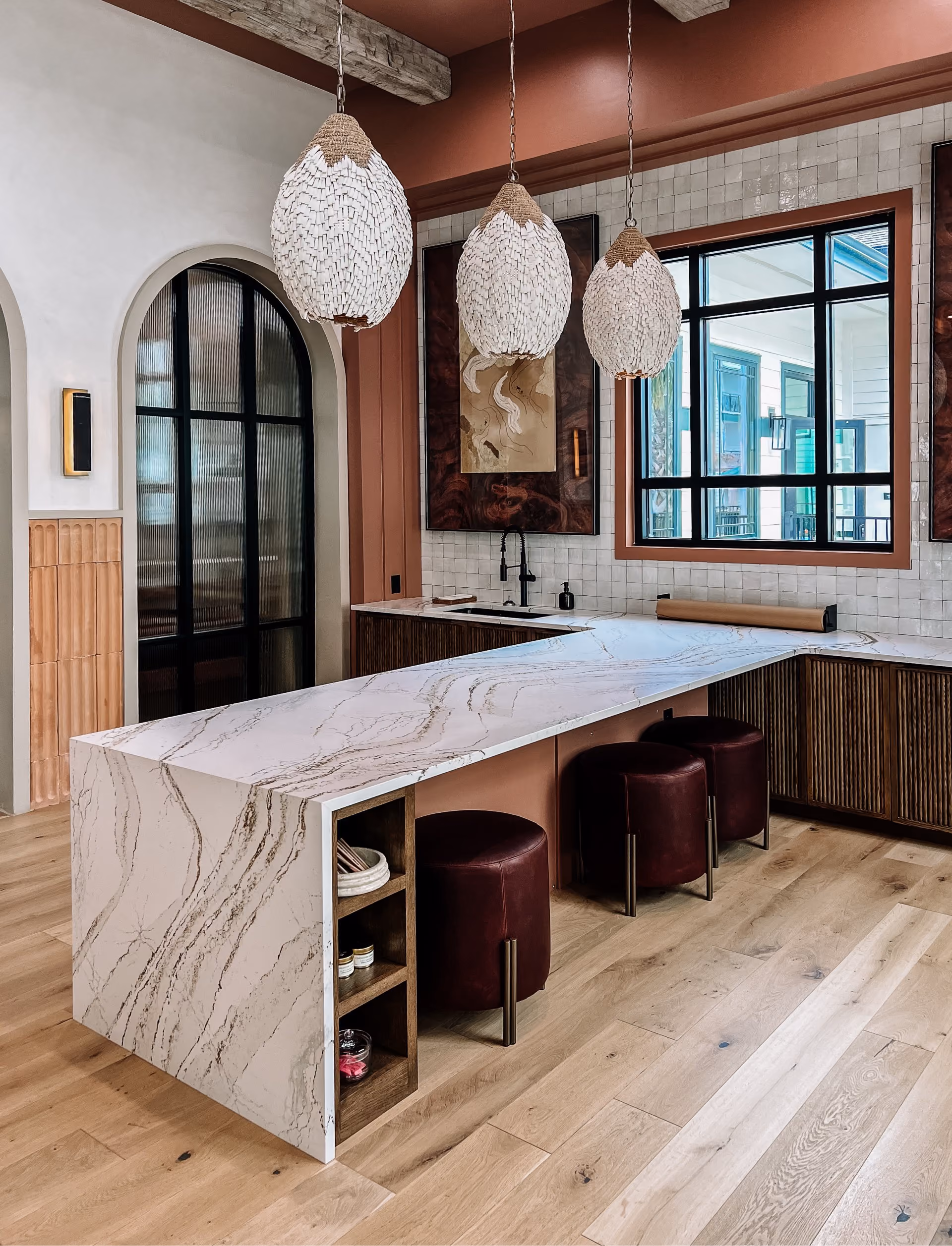 Kitchen with a marble waterfall island and wood-look flooring