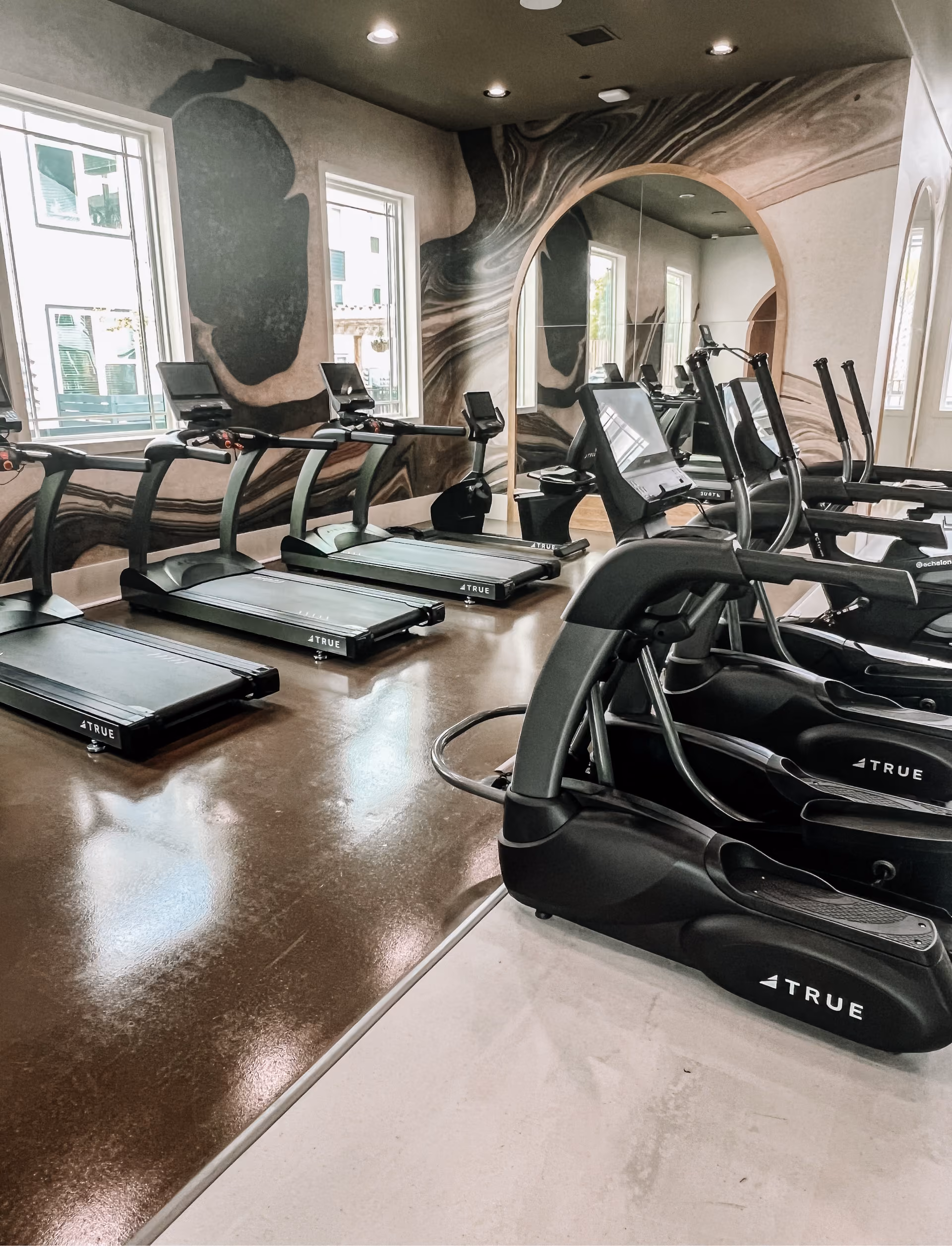 Fitness center with treadmills on wood-look flooring
