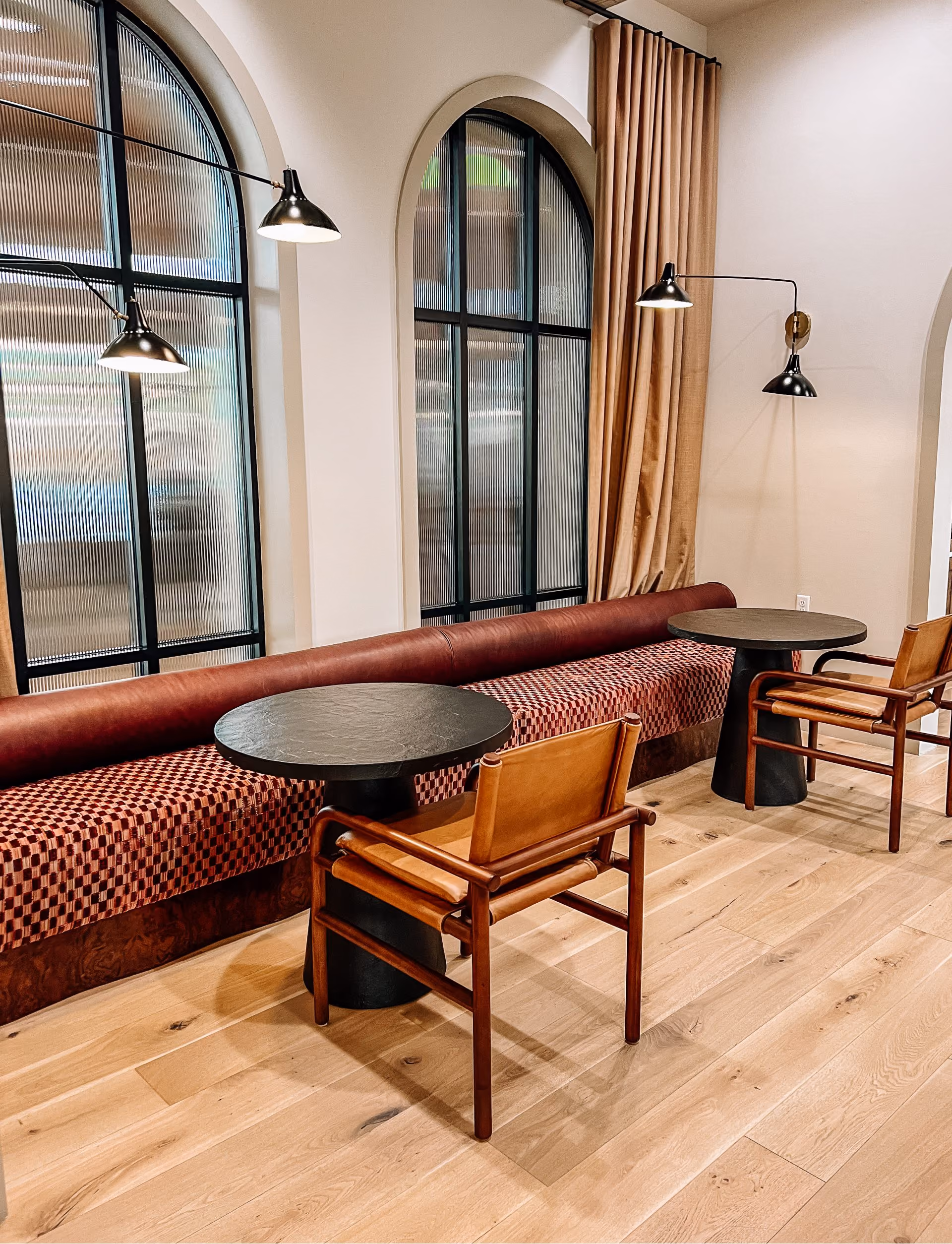 Lounge banquette seating with wood tables on wood-look flooring