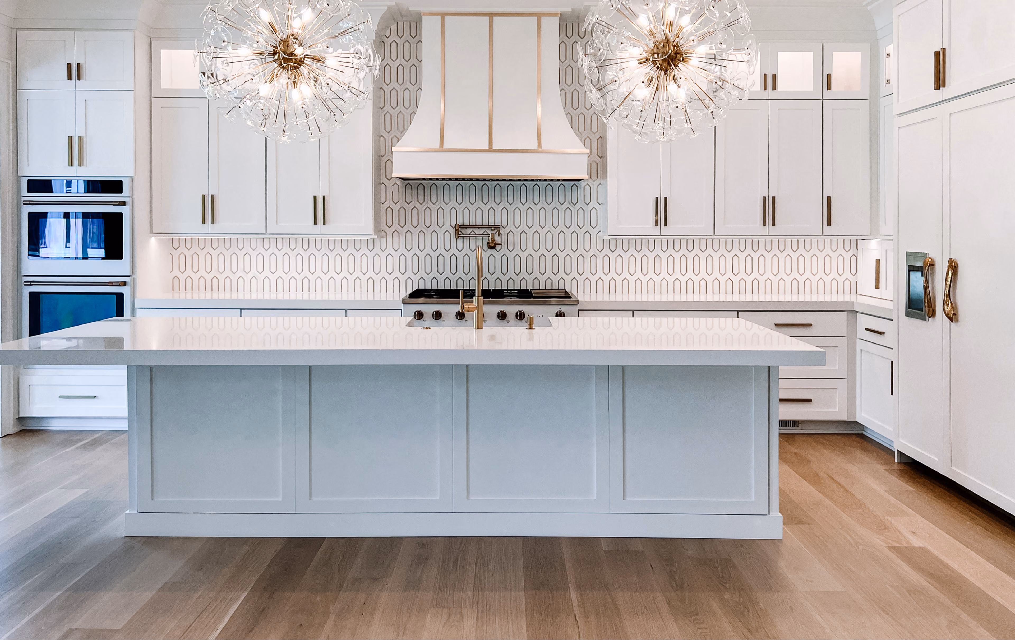 Kitchen with white cabinetry, statement pendant lighting, and wood-look flooring