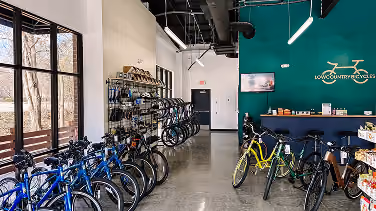 Bike storage room with a teal accent wall and polished concrete flooring