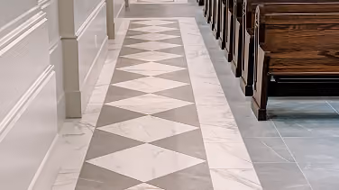Church sanctuary aisle with diamond-patterned marble tile flooring