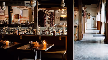 Dimly lit restaurant dining nook with candlelit tables