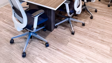 Office workstations with rolling chairs on wood-look flooring