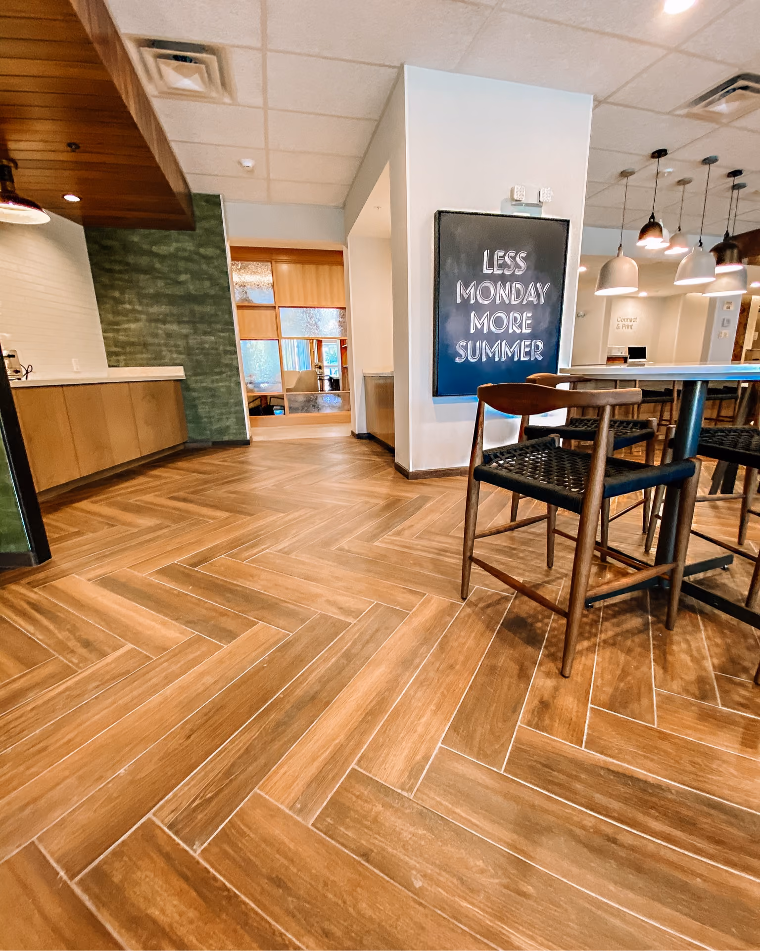 Close-up of herringbone-pattern wood-look flooring in a hotel setting