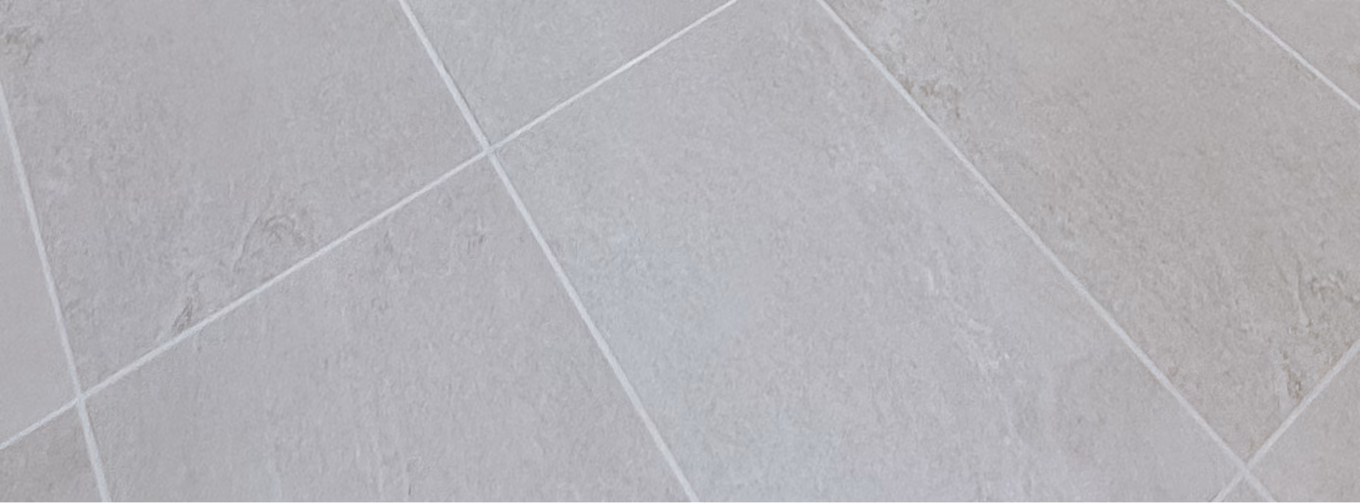 Close-up of light gray large-format tile flooring