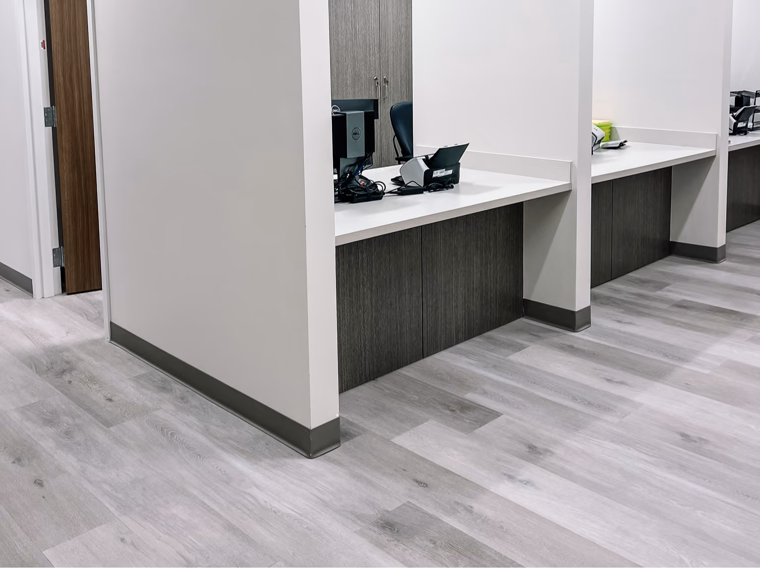 Healthcare facility corridor with a reception desk and light wood-look flooring