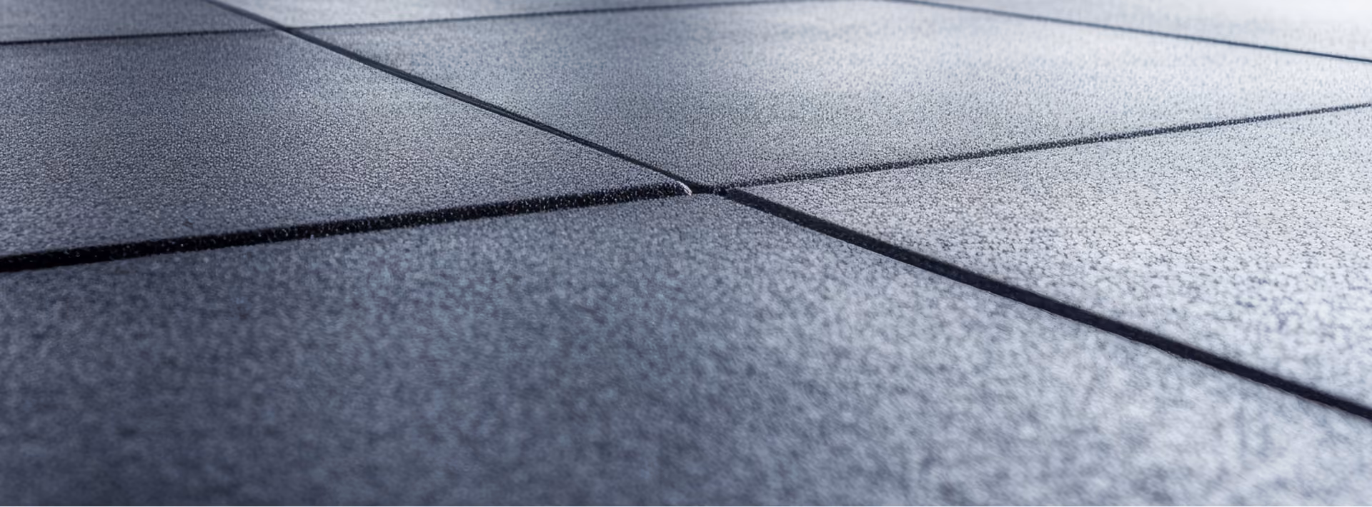 Close-up of gray slip-resistant flooring with X-pattern seams