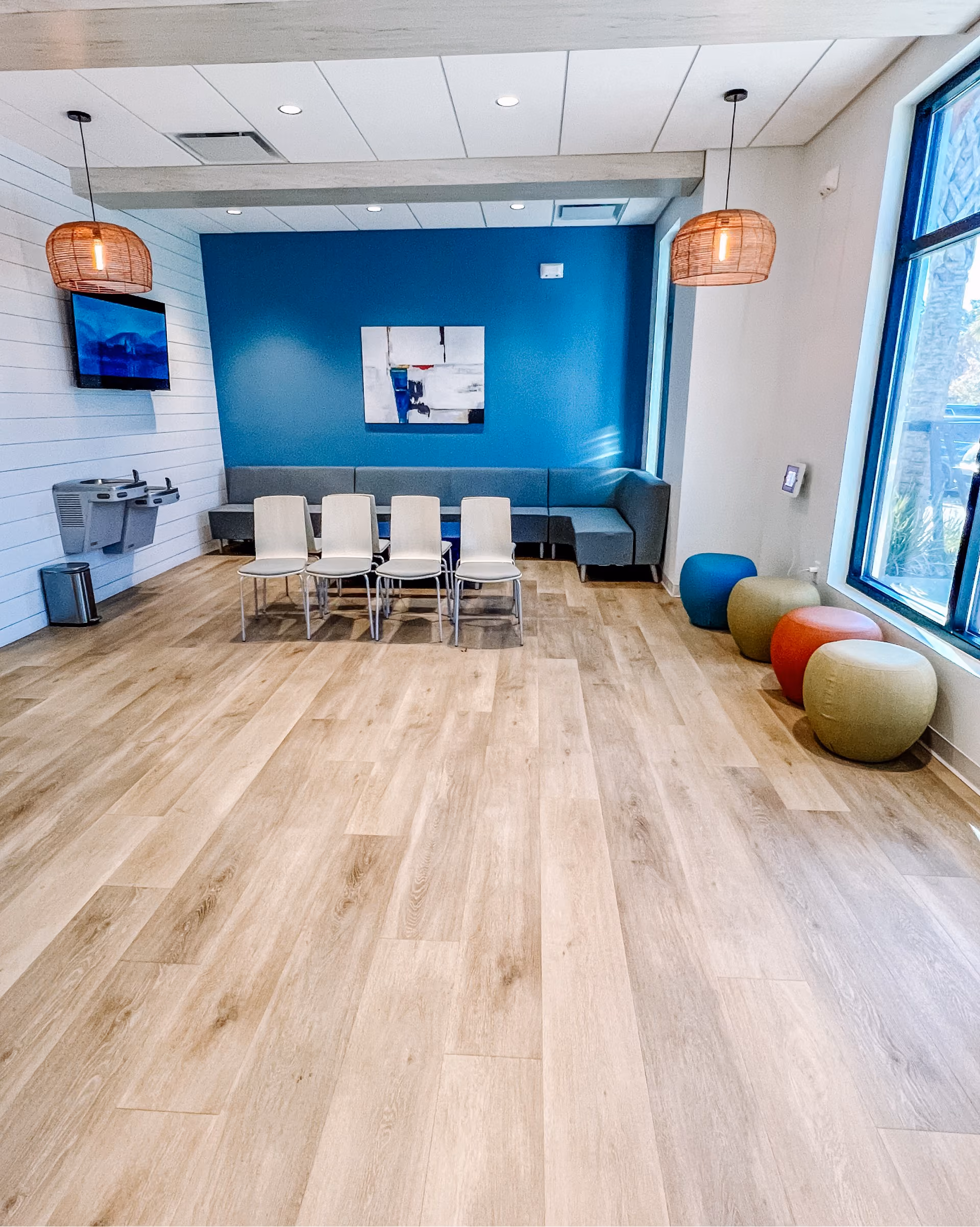 Healthcare facility lobby with a seating area and light wood-look flooring
